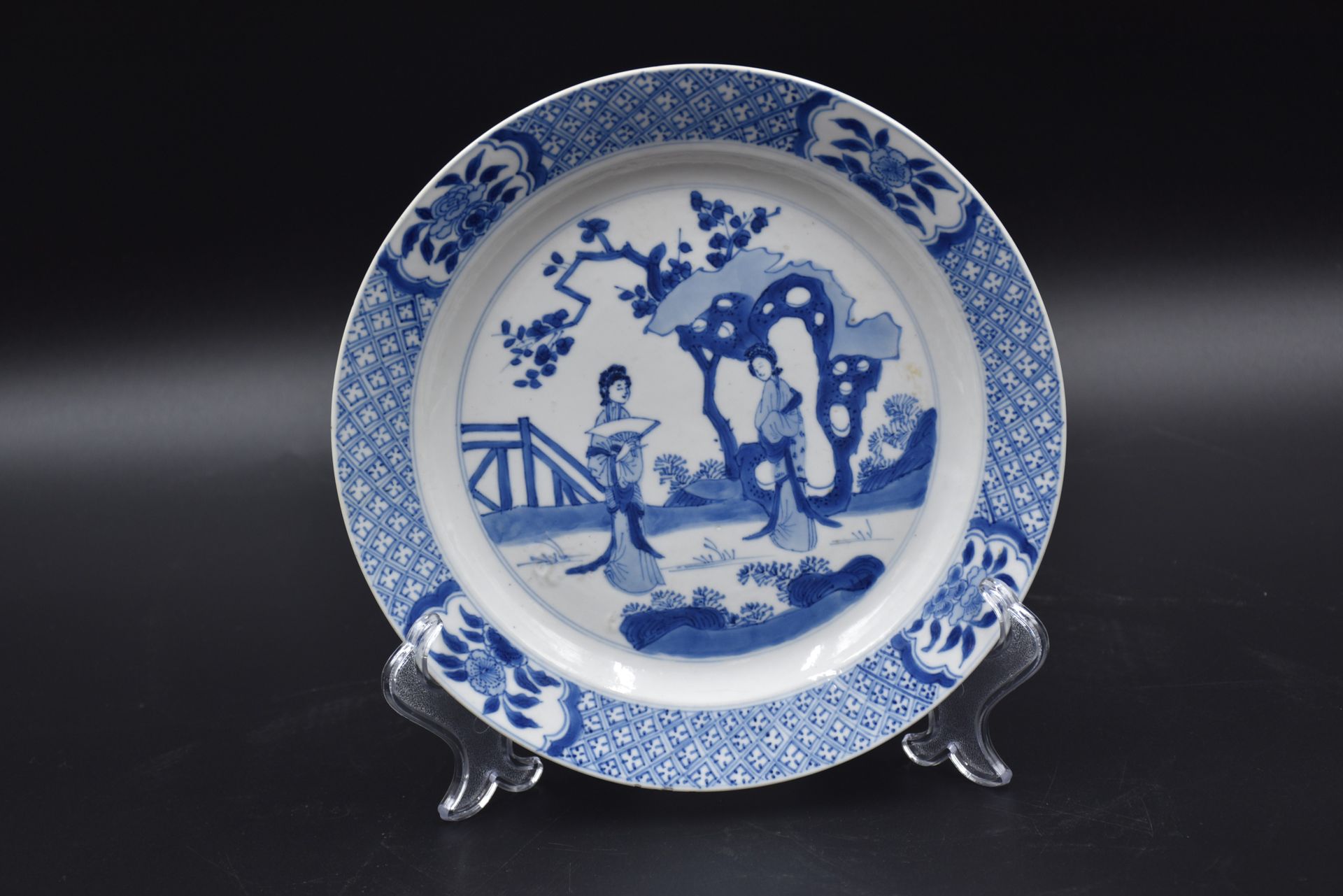 Null 
中国瓷盘，白/蓝相间的图案是两位优雅的女士在风景中。

直径：21厘米

边缘上有几个微小的、几乎不明显的缺口。

(这类作品的正常和通常状况)