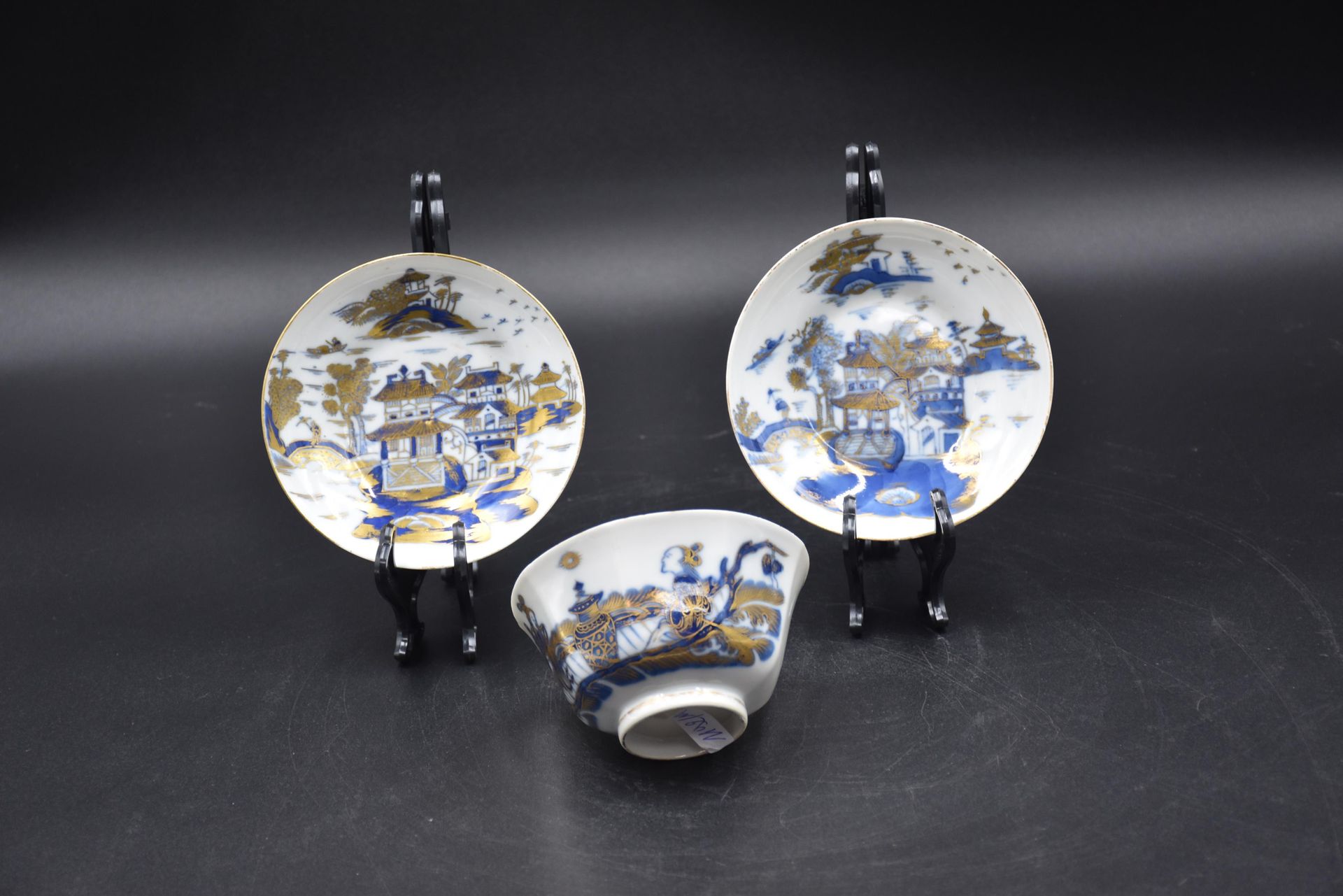 Null 一个中国瓷碗和两个碟子，上面有蓝色和金色的佛塔和人物的装饰。碗的尺寸：高度：6厘米。直径：11厘米。