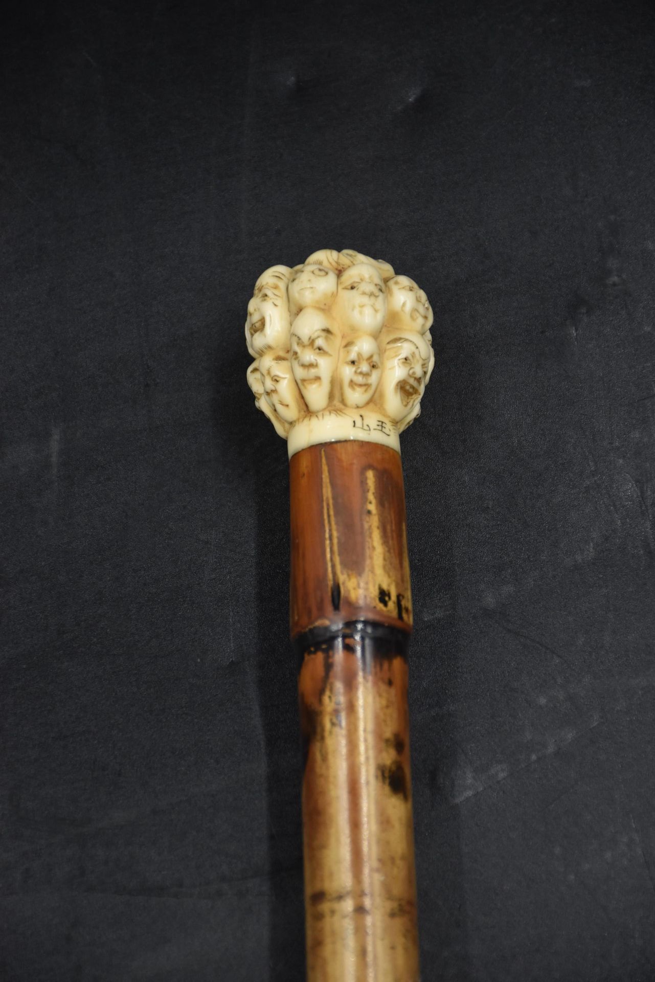 Null 
Canne au pommeau en ivoire sculpté du Japon à décor de masques Nô. Signé, &hellip;