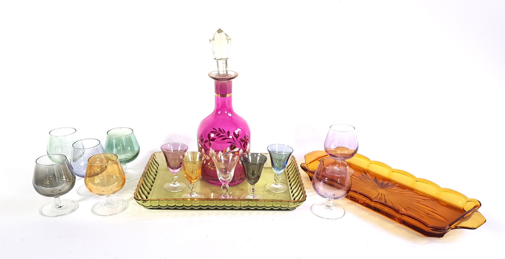 Null 两套五彩玻璃酒具，分别为五件和六件

两个托盘（一个有条纹）和一个装饰有花纹的玻璃瓶（瓶塞相连）。

瓶子的高度：28.5厘米

薯片