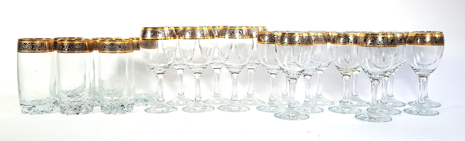 Null 金银色卷轴装饰的玻璃餐具，包括六个橙汁高脚杯，六个水杯和十二个酒杯

H.14,5 - 17和16厘米

穿着于装饰