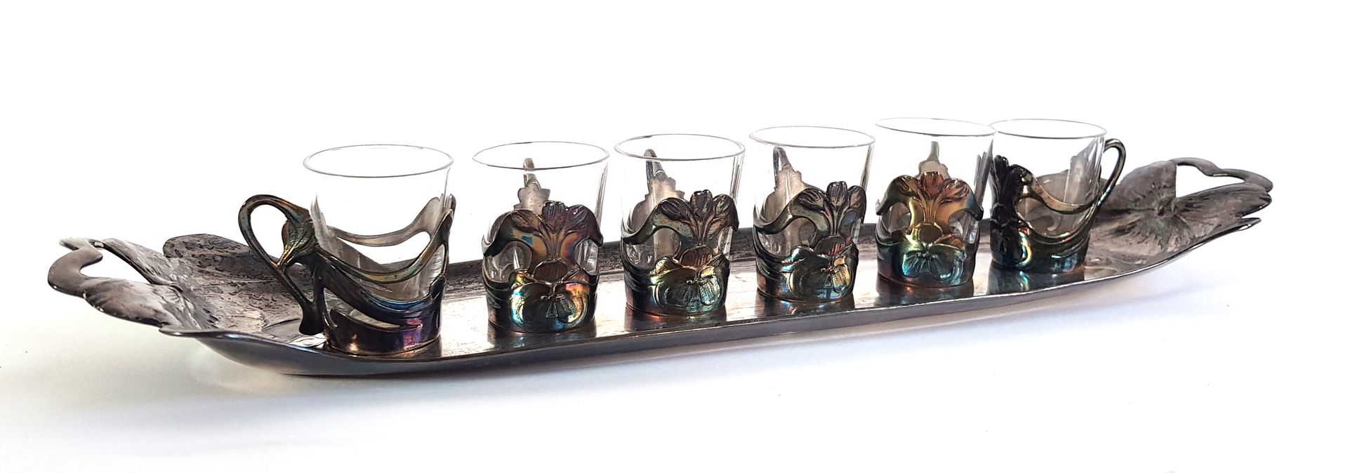 Null 新艺术派作品，约1900年

鸢尾花装饰的玻璃和镀银金属酒具，包括六个高脚杯和其托盘

戈德史密斯-盖利亚

托盘的长度为35厘米

高脚杯的高度：4&hellip;