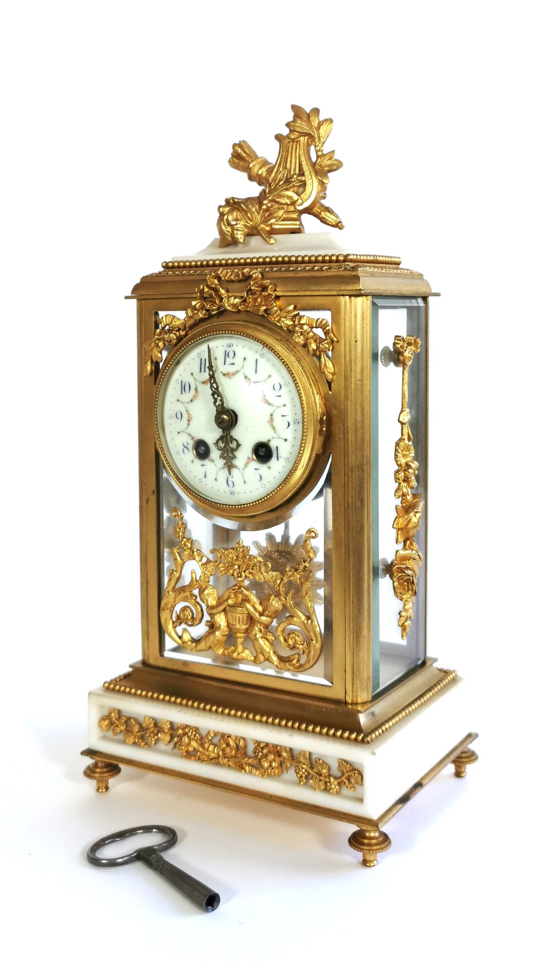 Null 新古典主义风格的壁炉钟，由带凹槽和镀金的青铜、大理石、珐琅和玻璃制成

带钥匙的机械机芯（未测试

H.31厘米