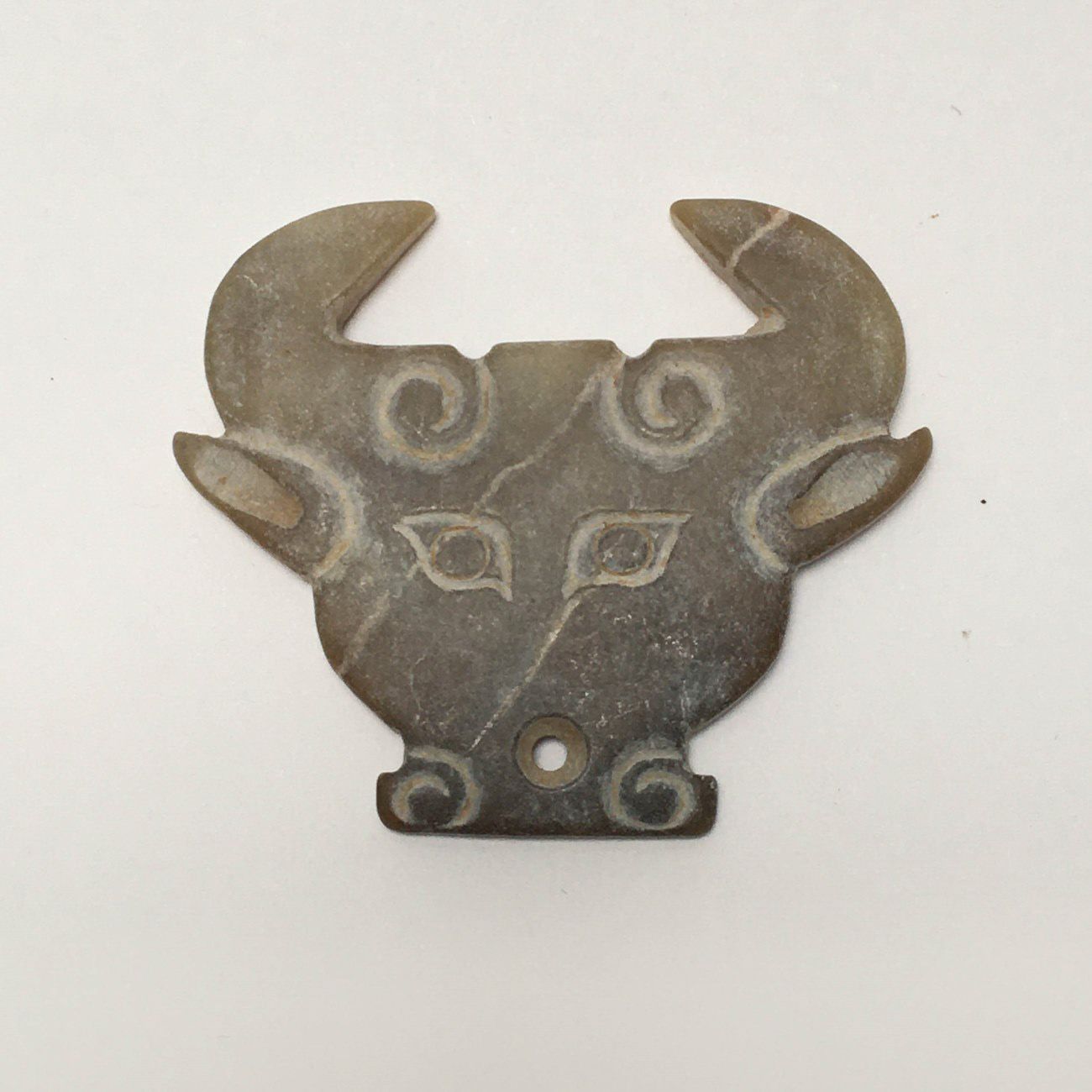 Null Very stylized brown/yellow jade bovine head. An earthy deposit is apparent &hellip;