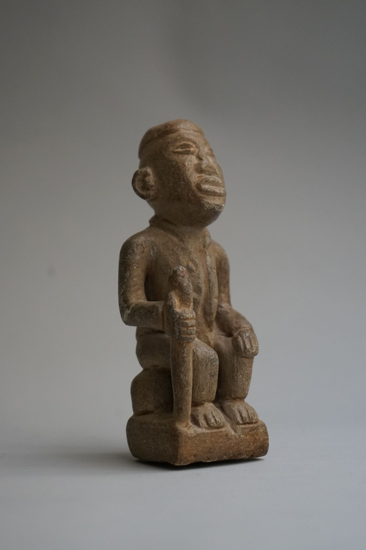 Null 图中显示一个坐着的酋长拿着一根棍子。石灰石。

刚果民主共和国。

高：15.4厘米