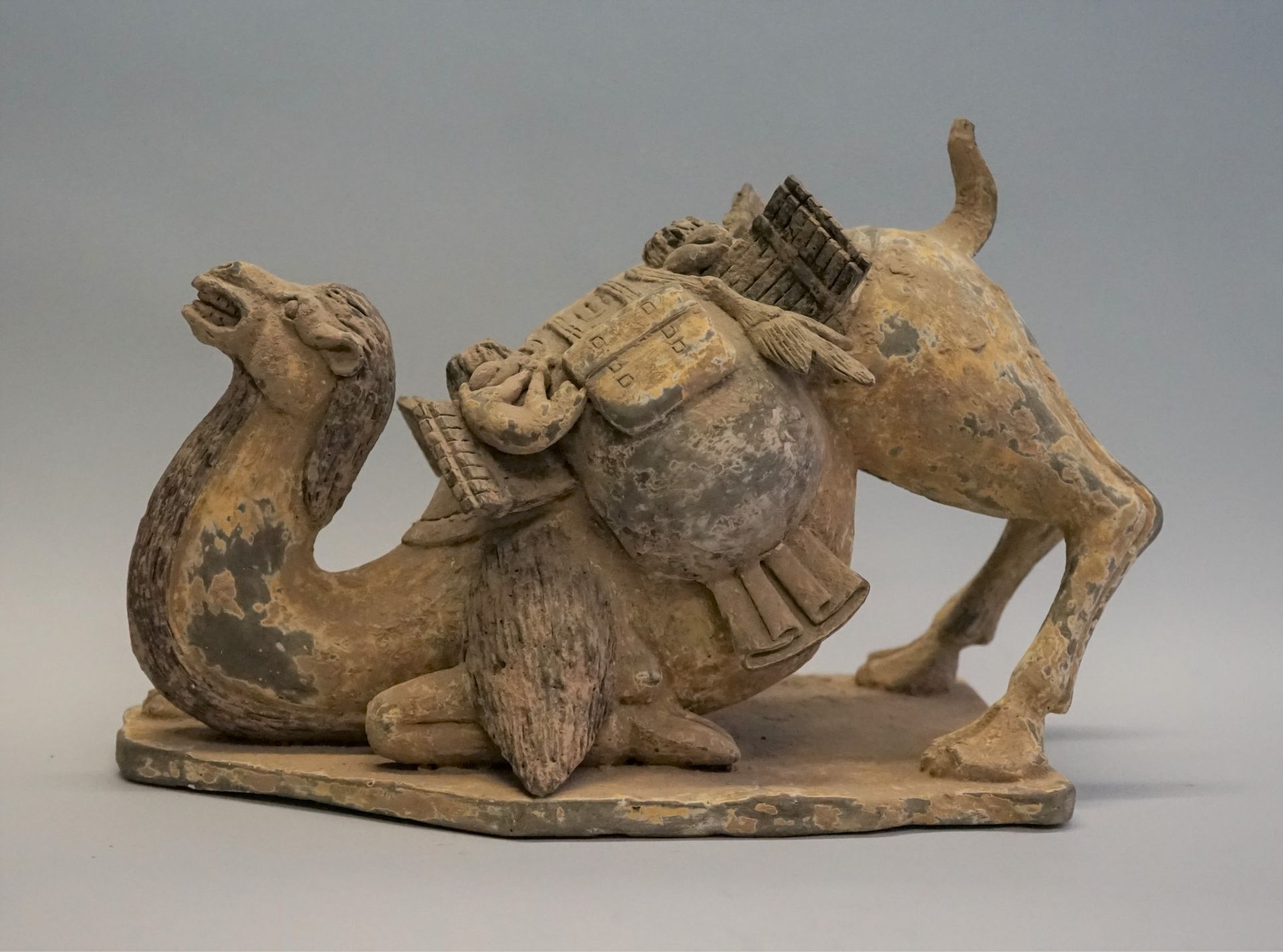 Null Kneeling camel carrying a pack of goods. Polychrome terracotta. Restoration&hellip;