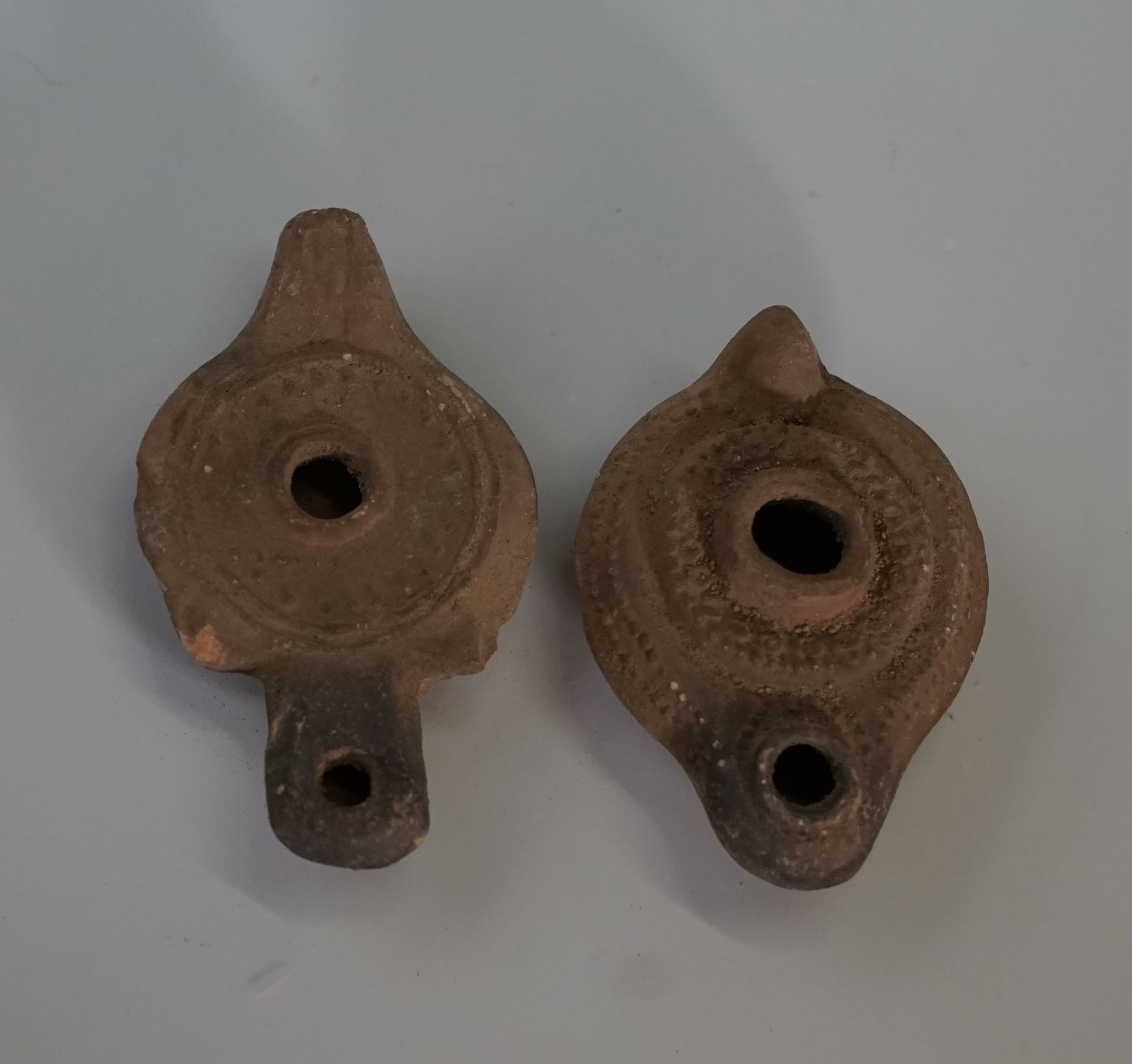 Null Set of two terracotta oil lamps in the Roman style.

L: 9 and 14cm