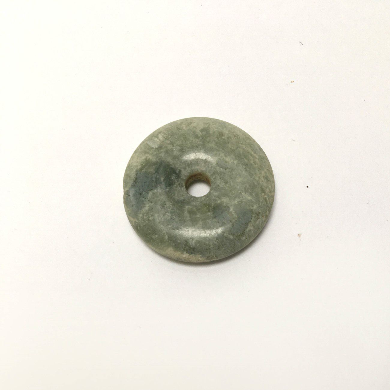 Null Green translucent chalcedony disc.

Undetermined period.

D: 2,7cm