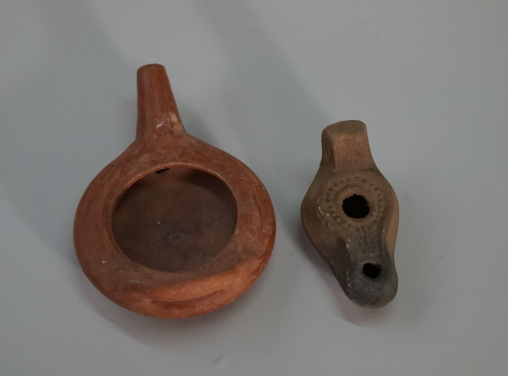 Null Set di due lampade ad olio in terracotta in stile romano.

L: 9 e 10.5cm