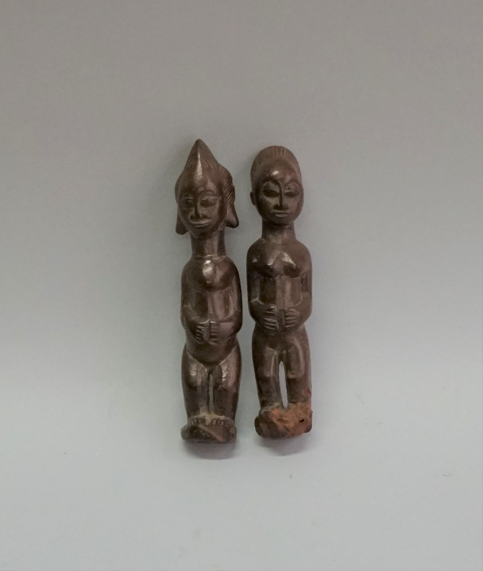 Null 两件木制的生殖器，有淡淡的铜锈。妇女将手放在肚子上，以示象征性的姿态。 班巴拉，马里。

高：13和13.5厘米