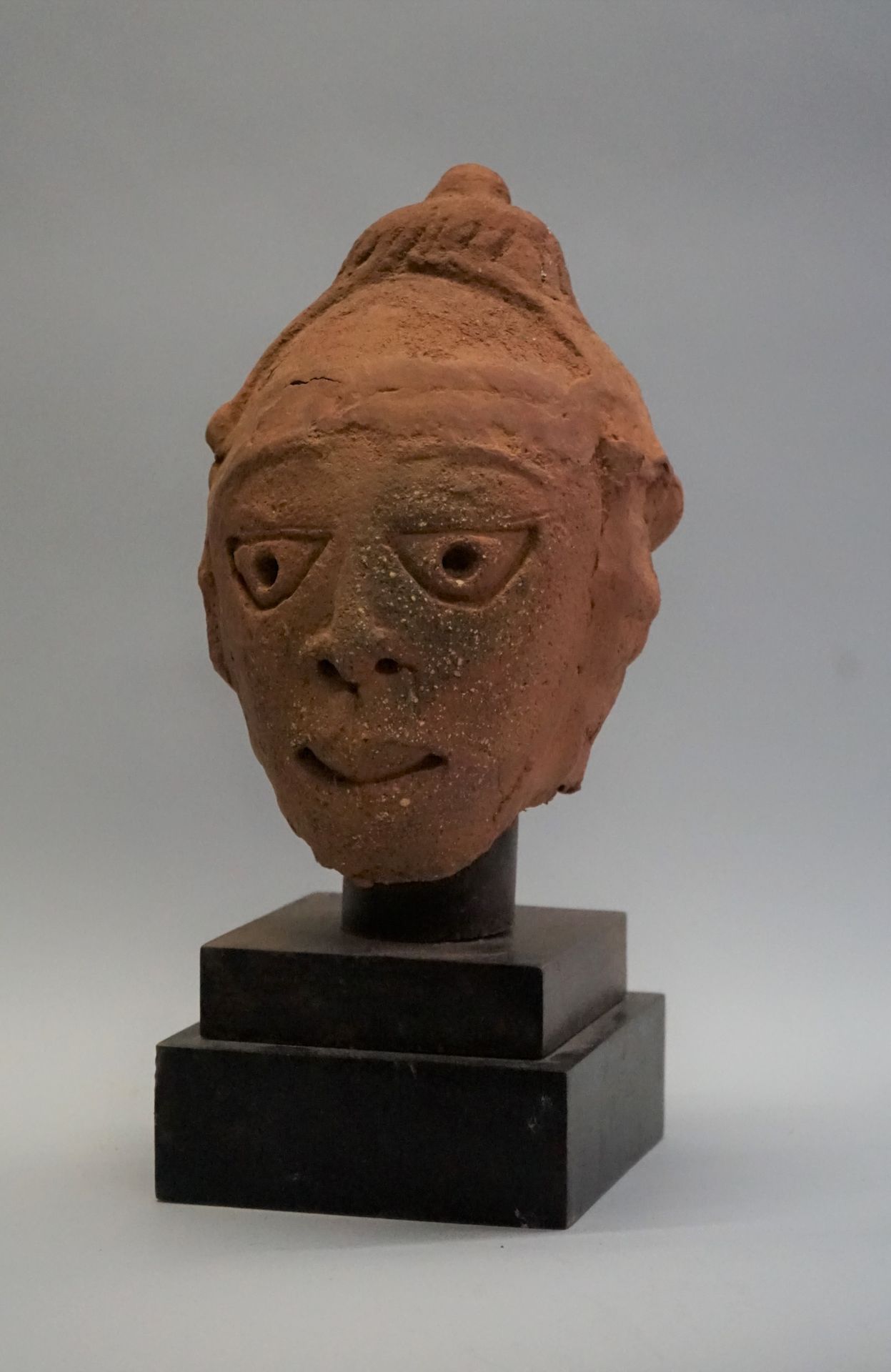 Null Head showing a face with incised triangular eyes. The headdress is made of &hellip;