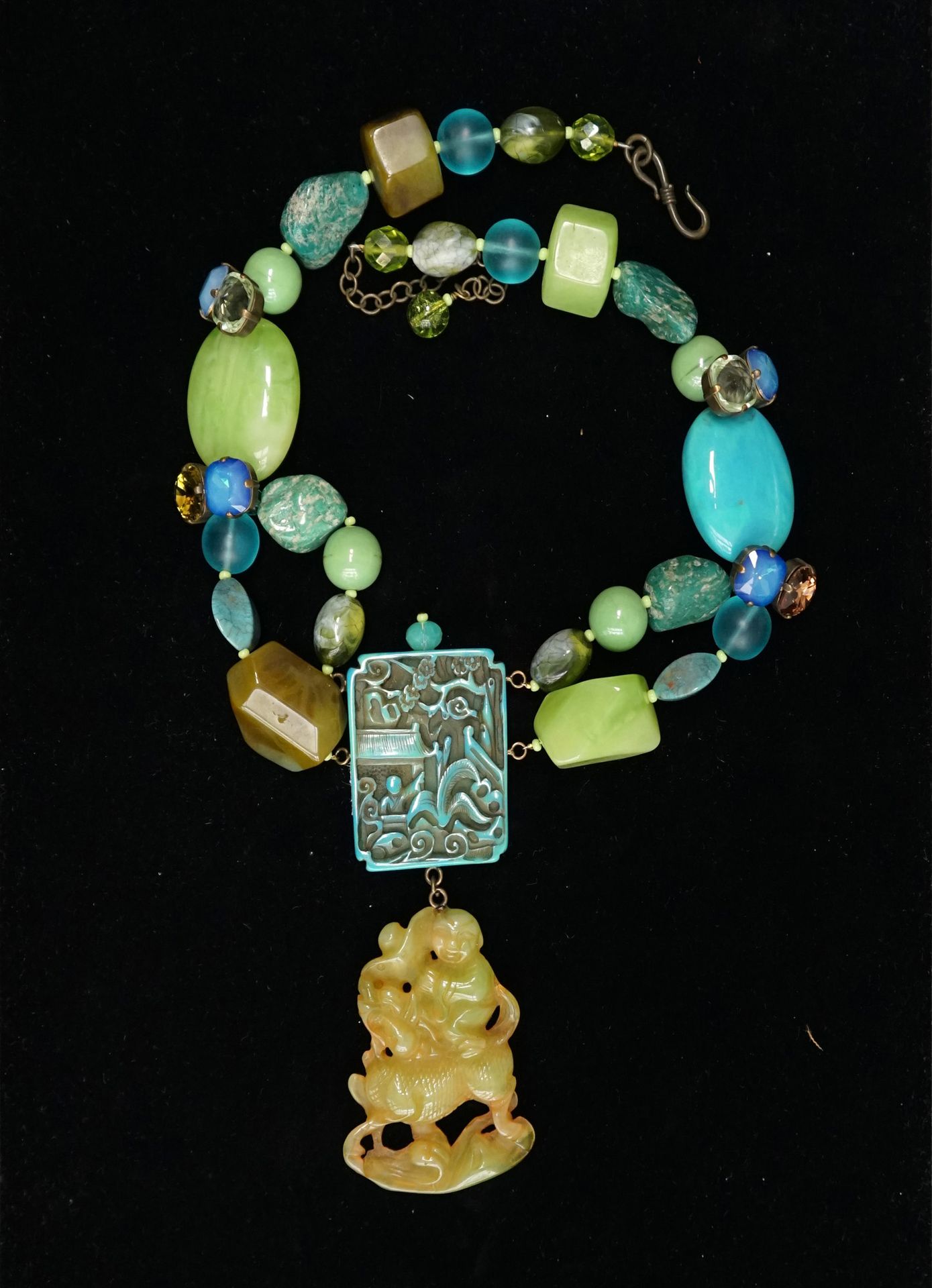Null 亚洲主题的 "高级定制 "项链，由各种形状的绿色和蓝色的复合珠子组成，与亚马逊石卵石交替，以一个长方形的元素为中心，装饰着船上的人物，手里拿着一个显示&hellip;