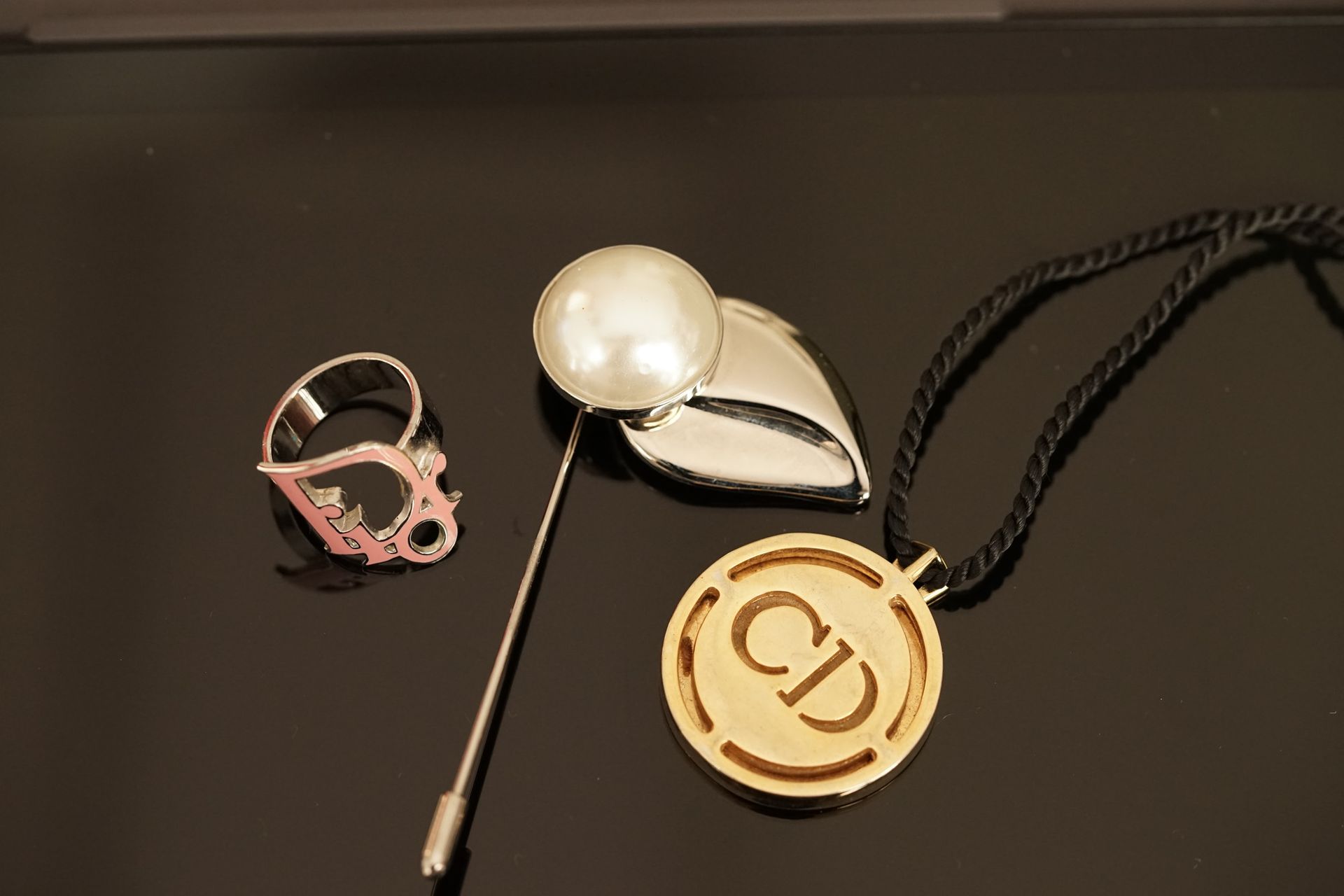 Null DIOR and FERRAGAMO - Ring, pendant and pin in gold or silver metal.