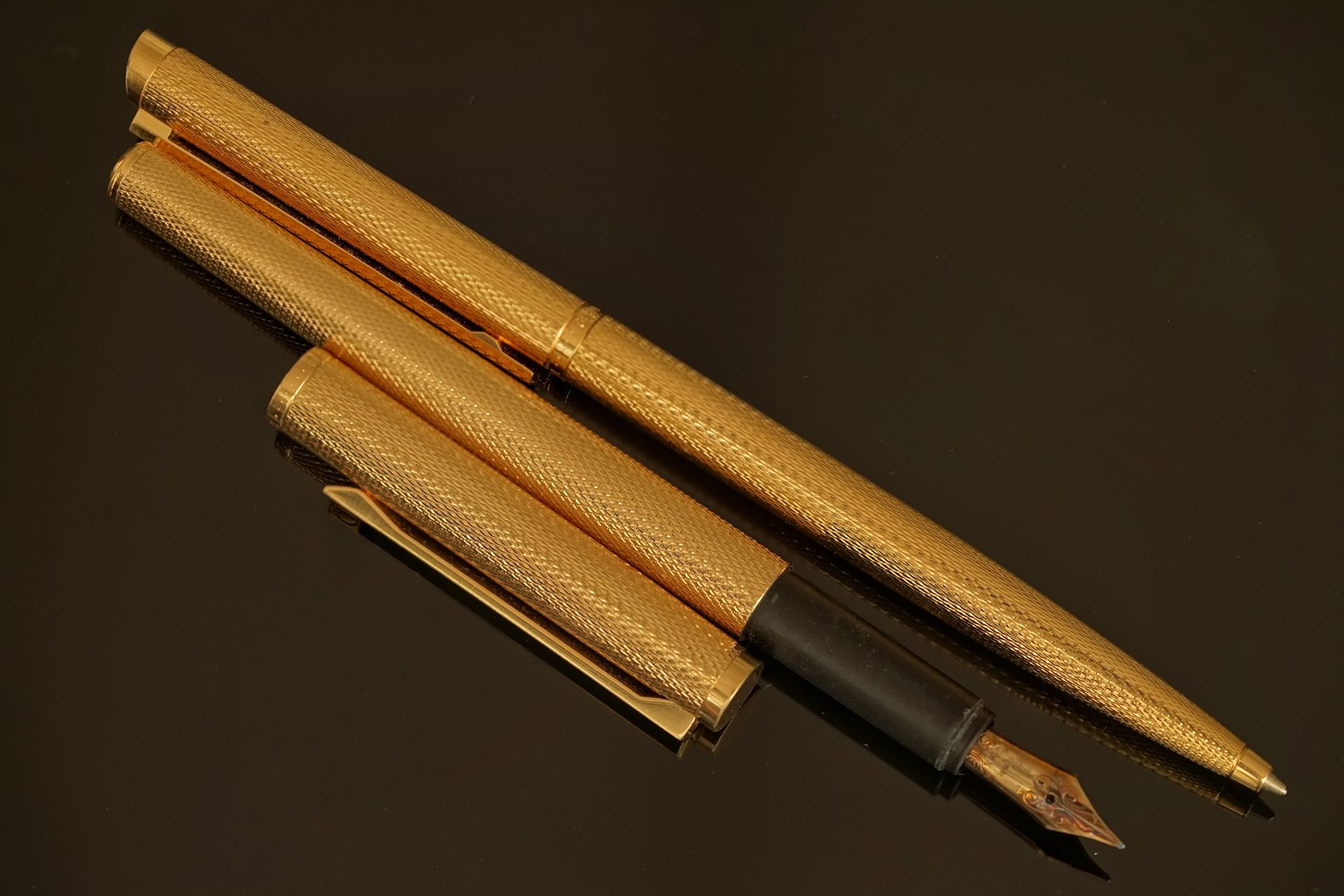 Null DUNHILL - 镀金金属玑镂图案的两件套，包括一支钢笔（18K金笔尖）和配套的滚珠笔。