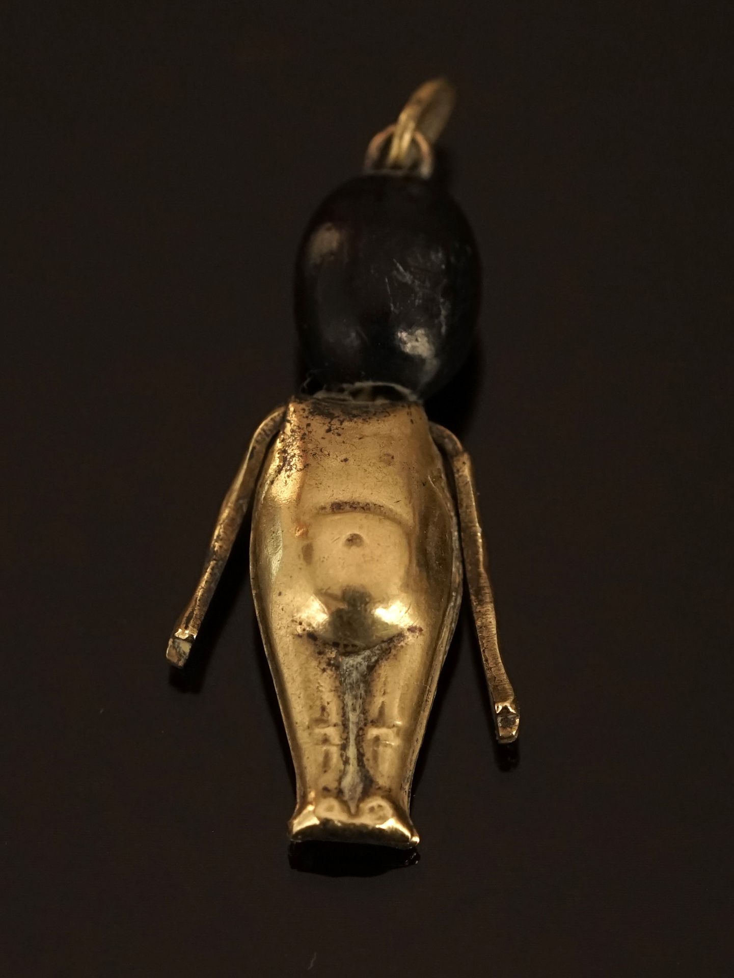 Null FUMSUP" pendant in gilded metal and wooden head. H: 2.8cm. With ring of bél&hellip;