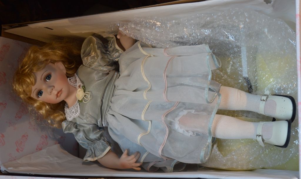 Un poupée en porcelaine DOLLS, tête 瓷制的胳膊和腿，睁着固定的眼睛，闭着嘴，在她的盒子里，有她的衣服和鞋子