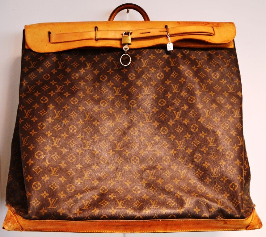 Louis VUITTON 蒸笼，大型旅行袋。
有图案的油布和天然皮革，镀金的金属饰边。
55 x 55厘米。
(磨损和水渍）。