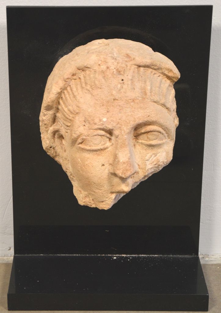 Fragment en pierre rosée représentant un bas relief un visage de jeune homme, la&hellip;