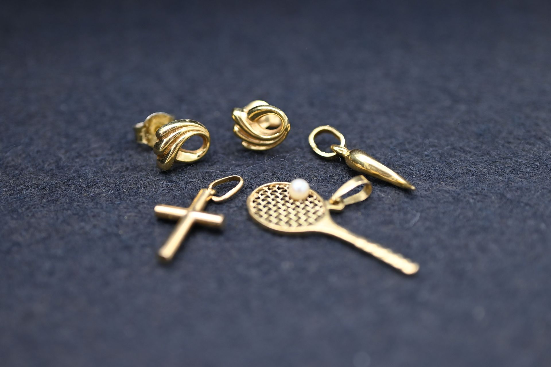 Null 一套黄金18K 750千分之一的珠宝，包括一对耳环和三个吊坠，代表一个胡椒，一个十字架和一个球拍，装饰着小珍珠。
毛重：3克