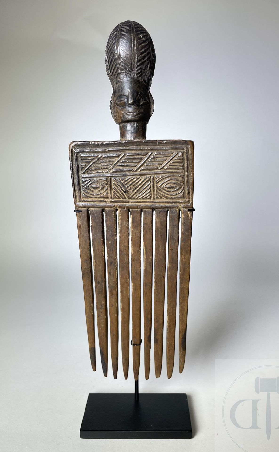 Null 形象化的梳子，有9个齿。 卢埃纳，安哥拉。 雕刻的木材。 时间：1910/1920。 高23厘米。 包括底座：高26厘米。 



出处。

收藏A。&hellip;