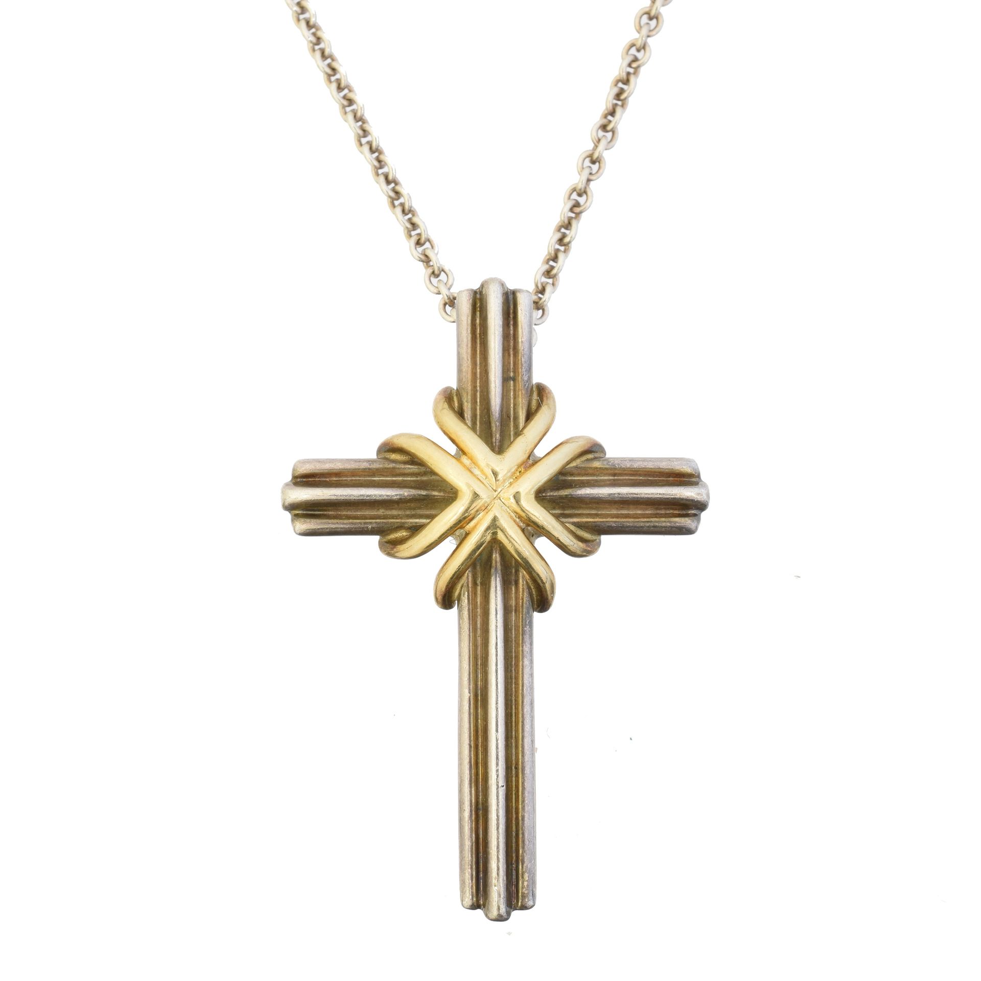 A Tiffany & Co. Silver and gold cross pendant, 
一个Tiffany & Co.银质和金质十字架吊坠，有凹槽的银质&hellip;