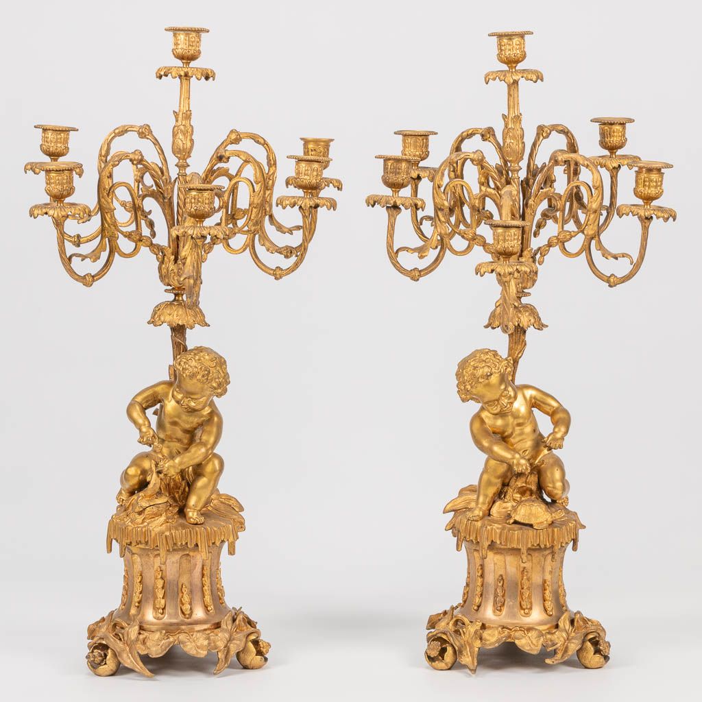 Null A pair of neoclassical candelabra decorated with putti, playing with pets. &hellip;