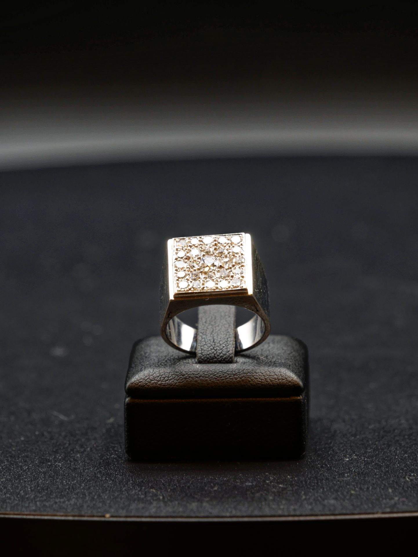 Null 
一枚白金方形标志戒指，镶嵌有24颗密镶钻石，围绕着一颗中央钻石，采用封闭式镶嵌。毛重：9,68g TDD : 52,5