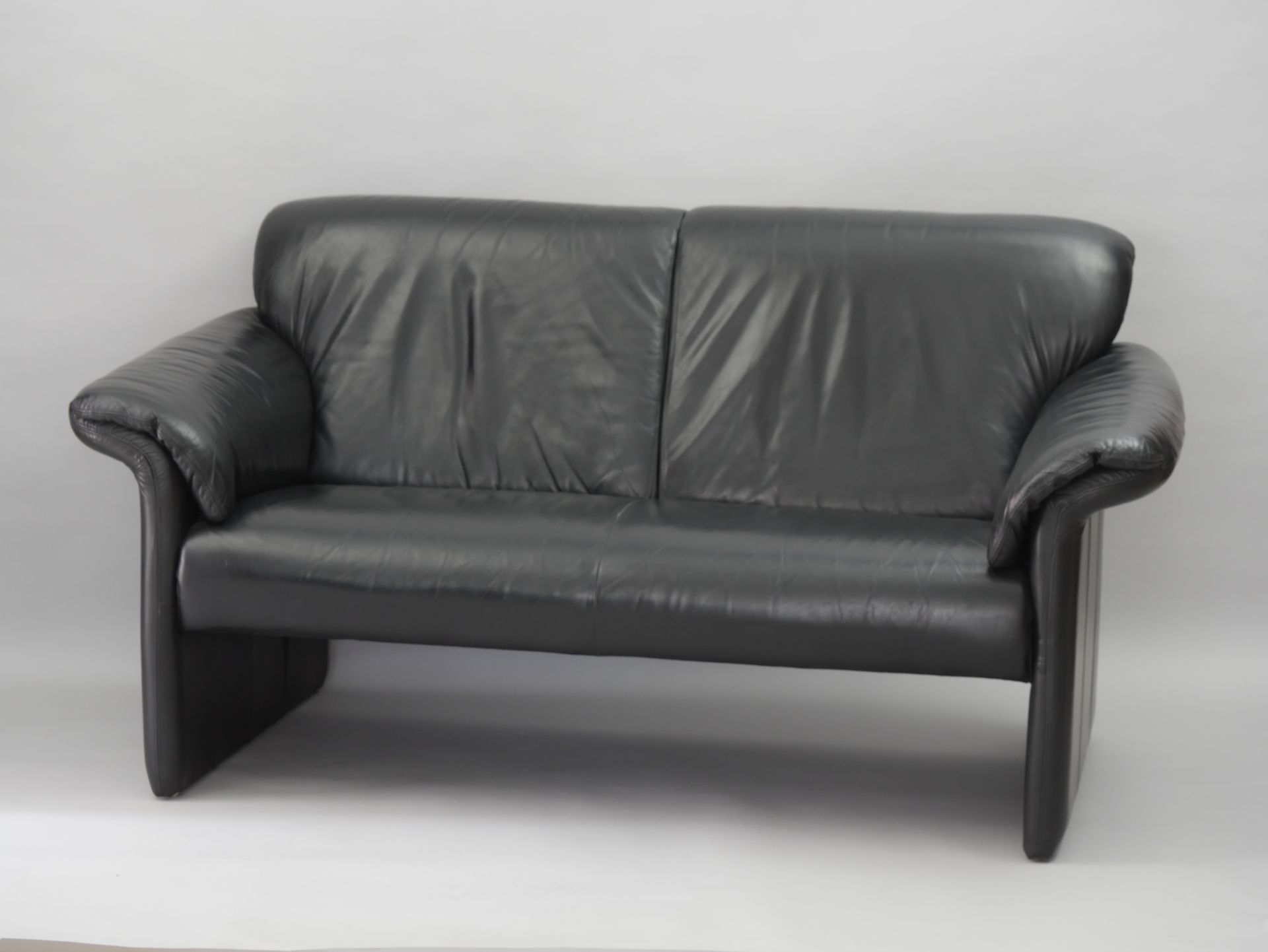 Null SKALMA，丹麦。两人座的黑色沙发，型号为 "马德里"。背面的侧面有一个标签。81厘米×157×80厘米。