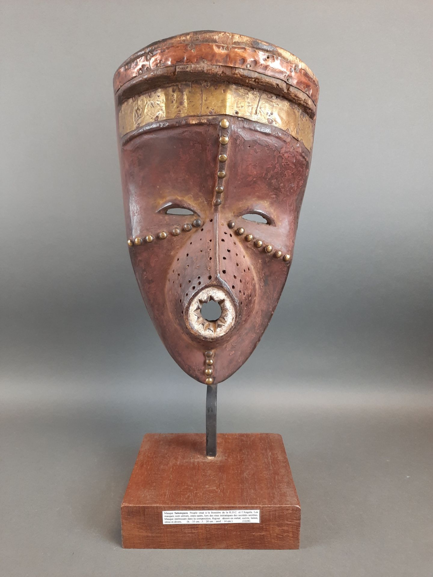 Null 好奇的木制面具，鼻子上有穿孔。圆形的嘴里有造型的牙齿。额头上的铜带。刚果民主共和国的SALAMPASU文化。高度：35厘米