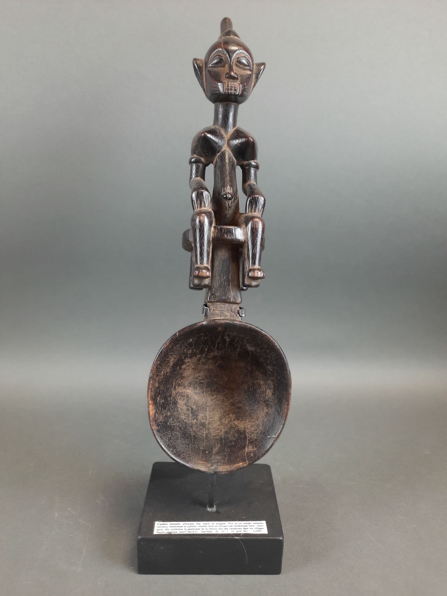 Null 仪式上的男性杓子，代表一个坐着的政要。他的双手放在膝盖上。美丽的黑铜色。象牙海岸的SENOUFO文化。高度：33厘米