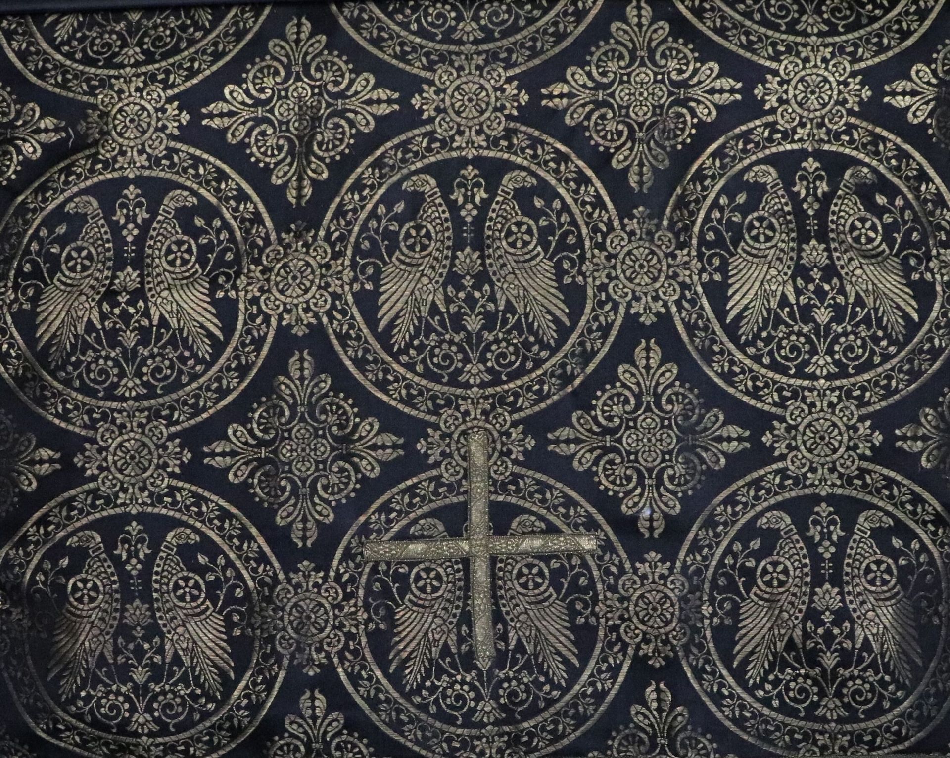 Null 黑底金线刺绣的织物，上面有分格的鸟类装饰。 
中间缝有一个十字架。 
19世纪末。 
被钉在一个框架里。
高53.5厘米，宽53厘米（布料）高51.5&hellip;