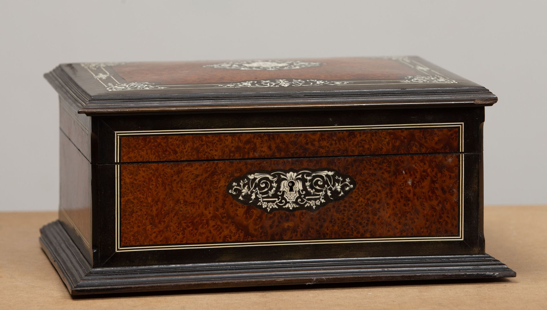 Null 树瘤皮和发黑的木质珠宝盒，装饰有骨质镶嵌，有 "ES "字样。
拿破仑三世时期。
标签 "P.Pignot, 53 passage des panor&hellip;