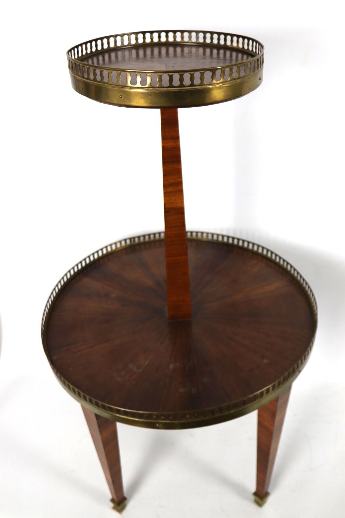 Null 双层桃花心木贴面的基座桌，有两个黄铜廊顶，放在四个锥形的腿上。
路易十六风格，19世纪末。
高_77厘米，深_44厘米，单板略微凸起，有浅色污渍。