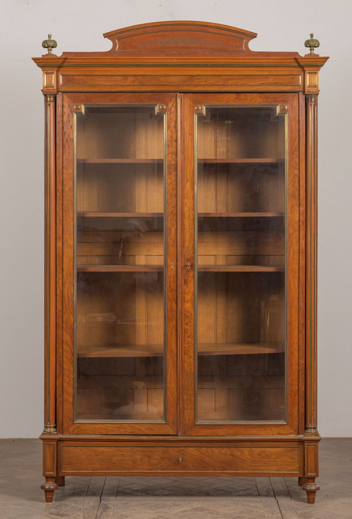 Null 饰面木材的书柜，带有黄铜装饰，有两扇门。
门框上装饰着卡索莱特。
路易十六风格，19世纪末。
高_245厘米，宽_148.5厘米，长_54厘米