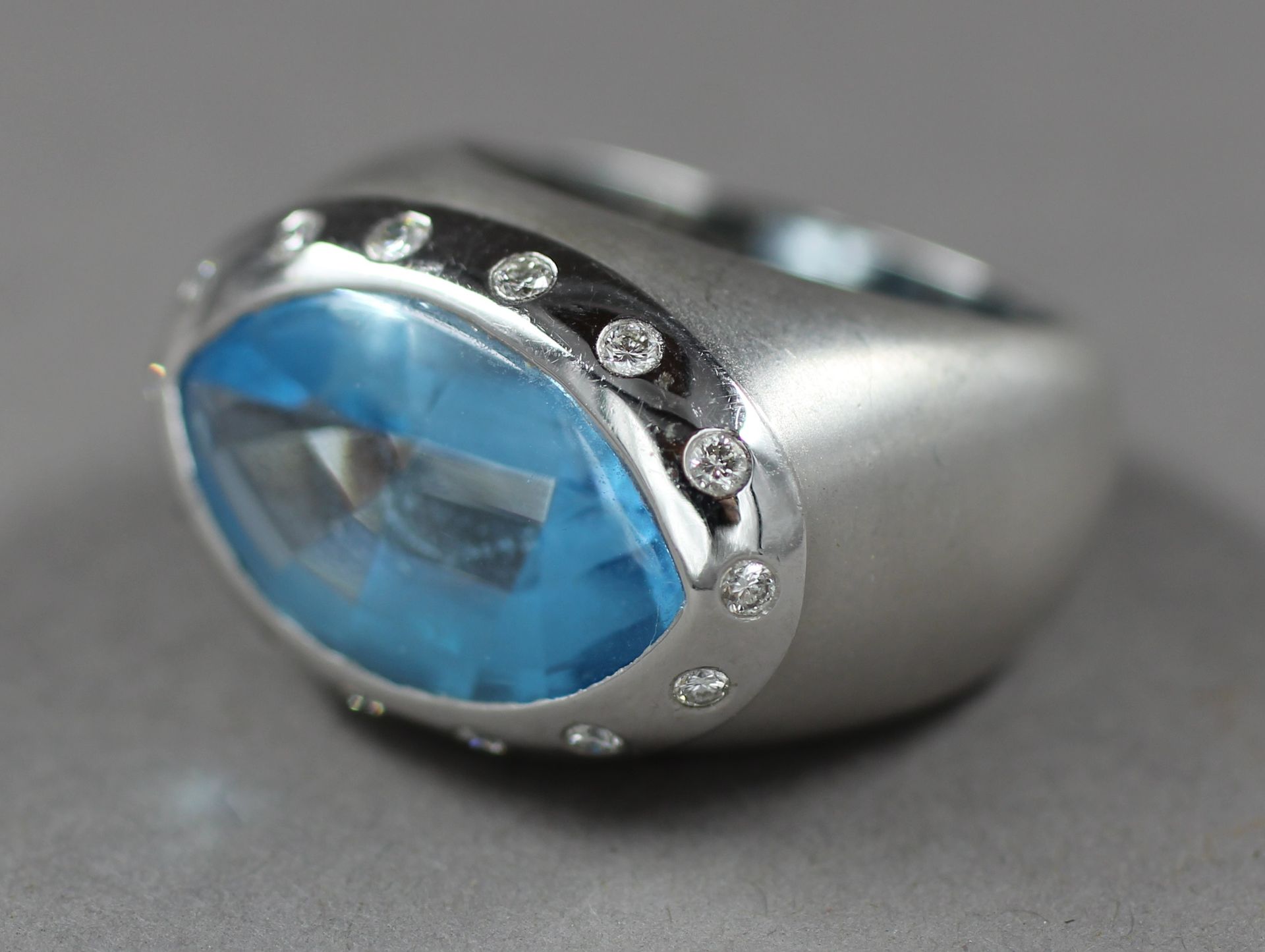 Null 
磨砂18K白金戒指，镶嵌一颗华丽的蓝色宝石，周围有亮片，原重：16克，TDD：55。