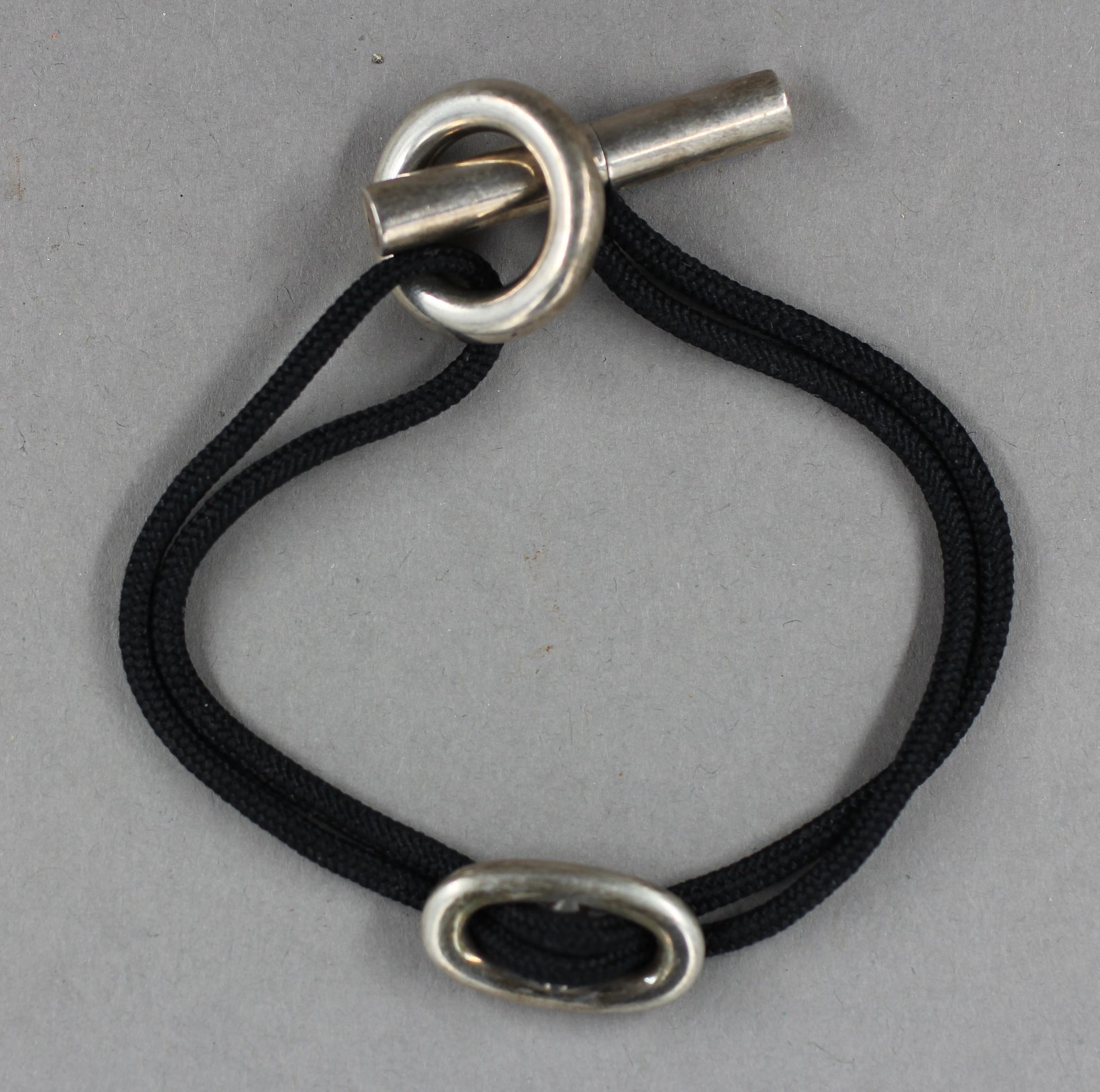 Null 爱马仕

Skipper手镯，黑色绳索上的925°/°°银色杆扣和锚链环，已签名。

毛重：16.3克。- 长度：18厘米