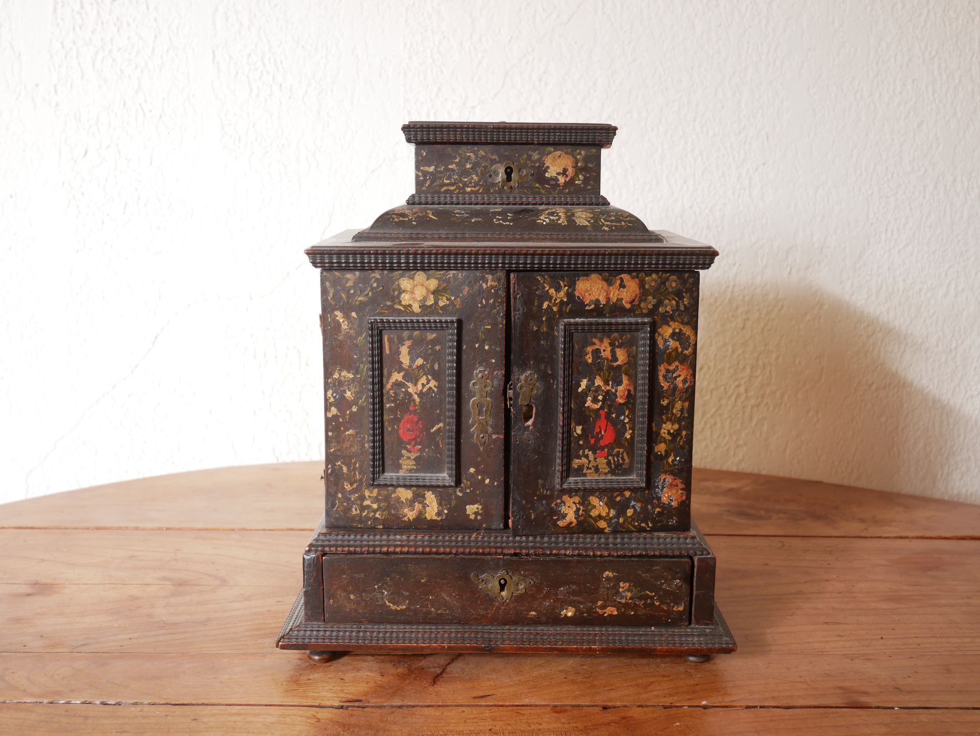 Null 一个发黑的木质四角柜，上面绘有花卉、人物和风景的装饰，具有十七世纪的风格。

高：31、宽：25、深：16厘米（磨损、部件缺失、意外）。