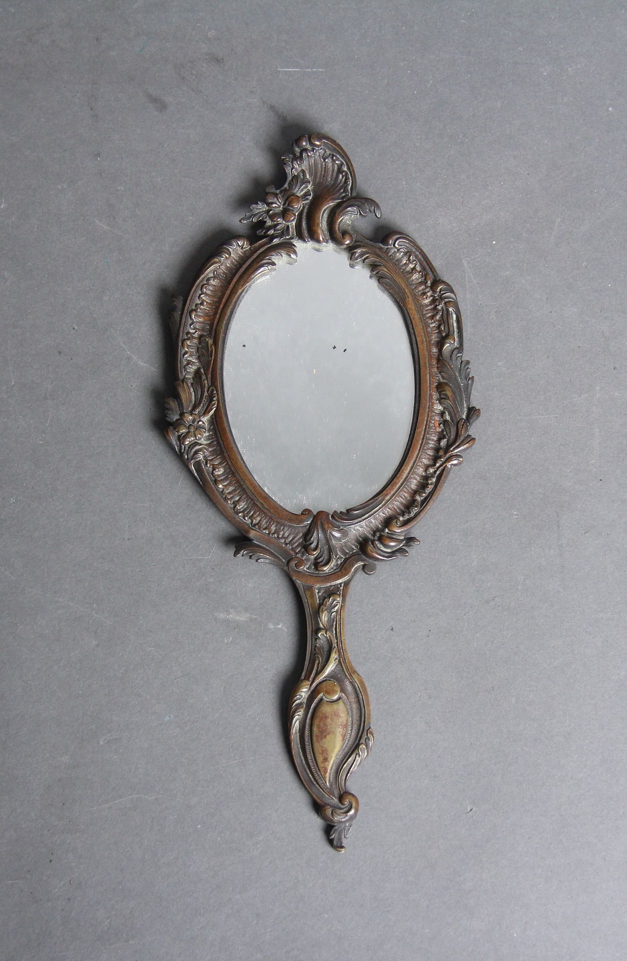 Null Un espejo de mano estilo rocaille de bronce

H: 30 cm.