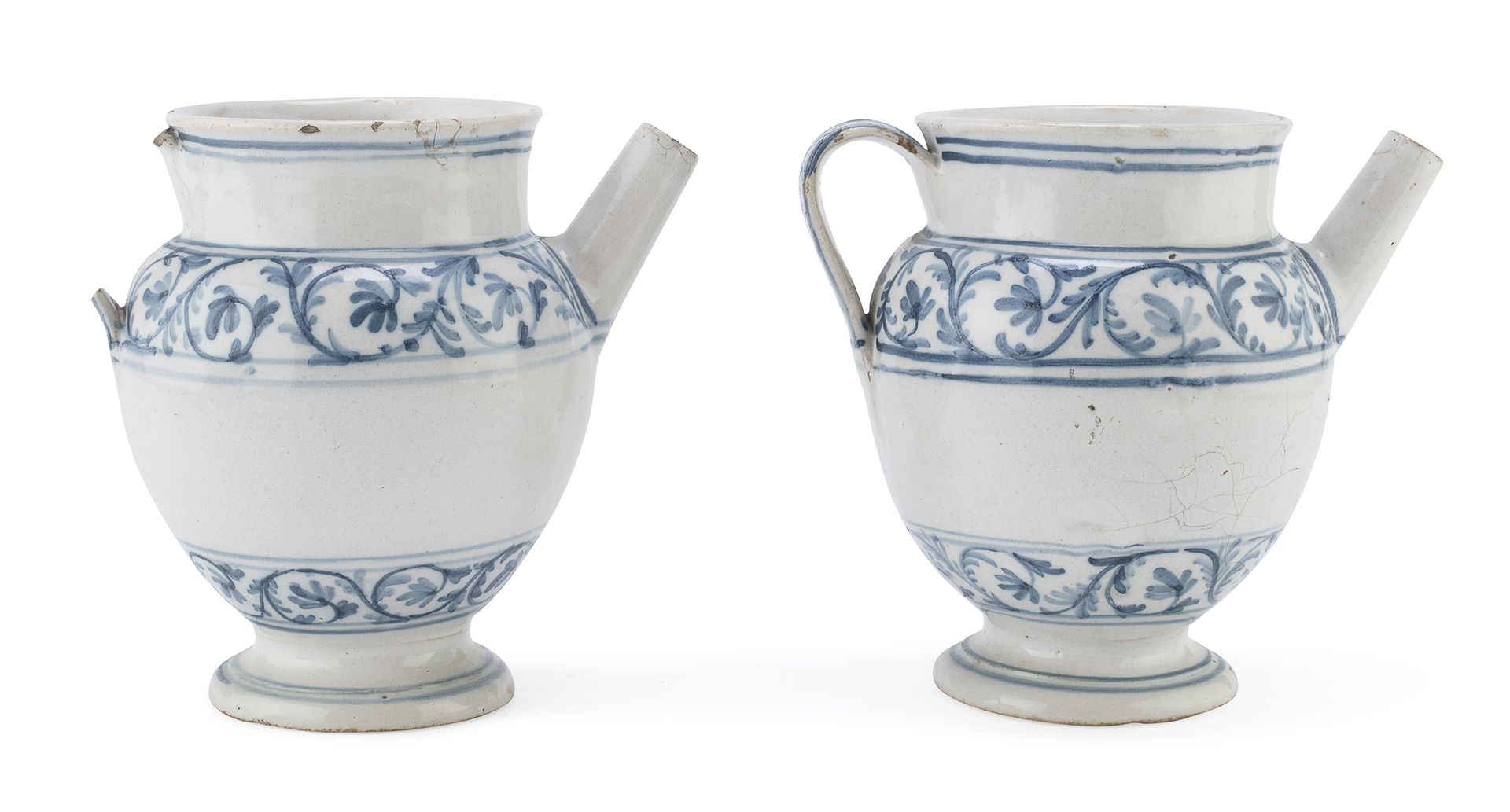 Null 成对的马戈里卡水壶，18世纪末

白色和蓝色的珐琅，主体装饰有一圈扭曲的植物图案。

尺寸为19 x 14 x 20厘米。

缺少一个手柄，边缘有缺陷&hellip;