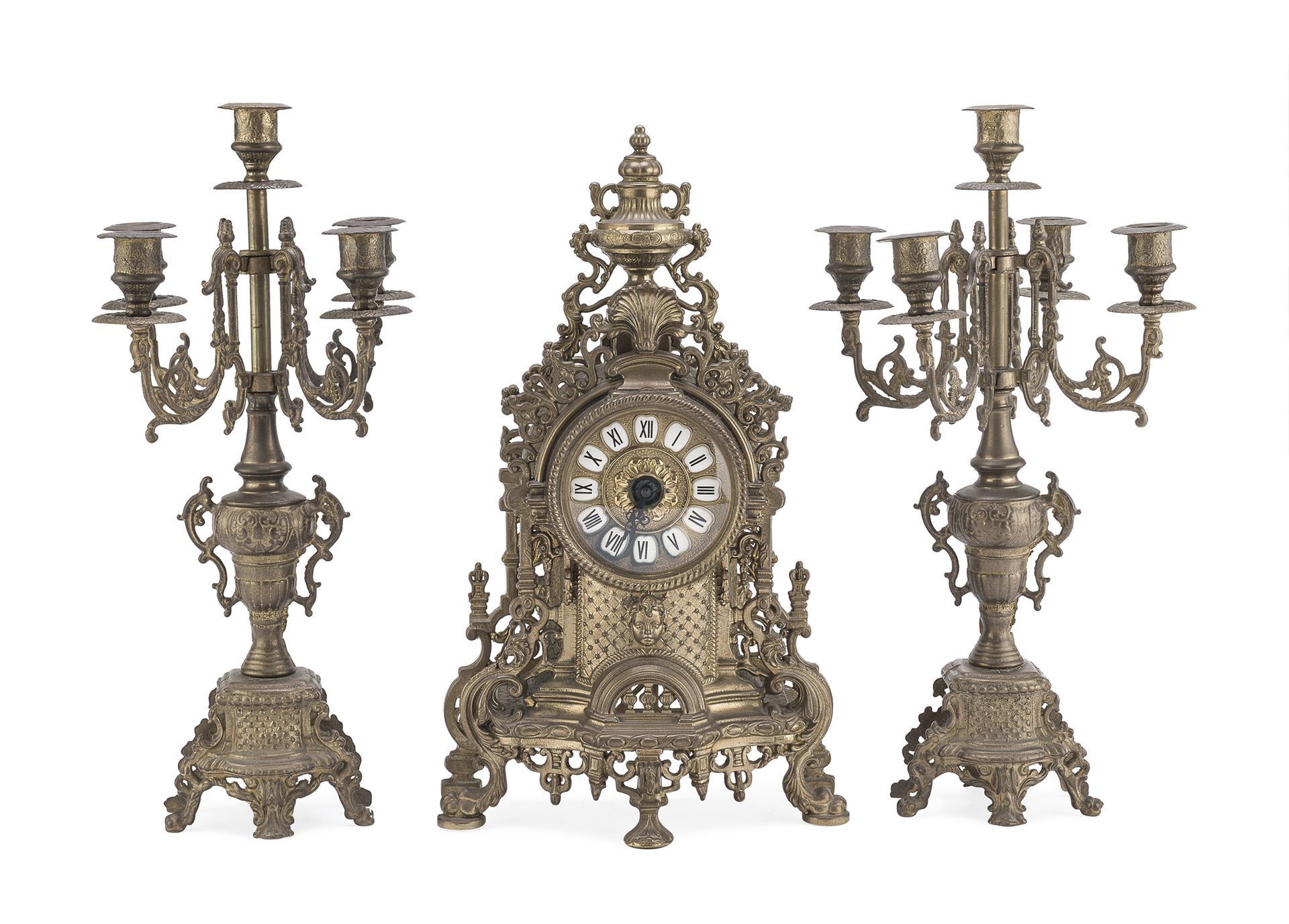 Null 青铜壁炉三联画，19世纪末

钟表上装饰有植物的涡旋，头部和网纹。表盘上有白色珐琅斑块。五臂式烛台。

时钟尺寸为42 x 25 x 14厘米。
