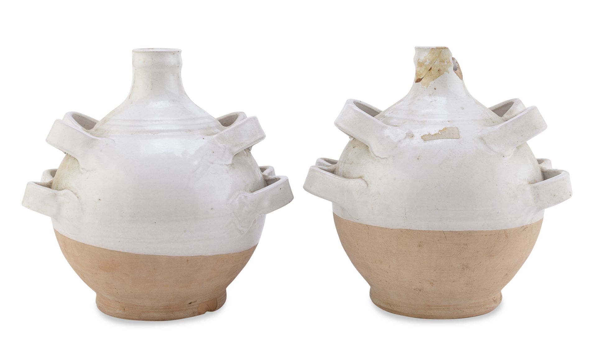 Null 一对陶制水壶，意大利南部，20世纪初


局部施白釉，有侧边的带状插口。


尺寸为30 x 26 x 23厘米。


壶口处缺失，有缺口。