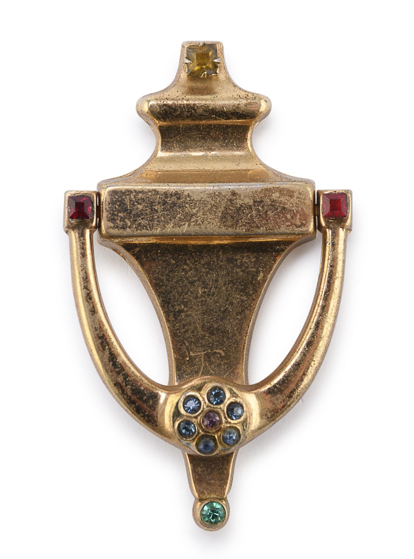 Null 镀金金属胸针，20世纪50年代杜埃特合唱团


铰链式外形，镶嵌绿色和红色宝石。


尺寸为6.5 x 4厘米。