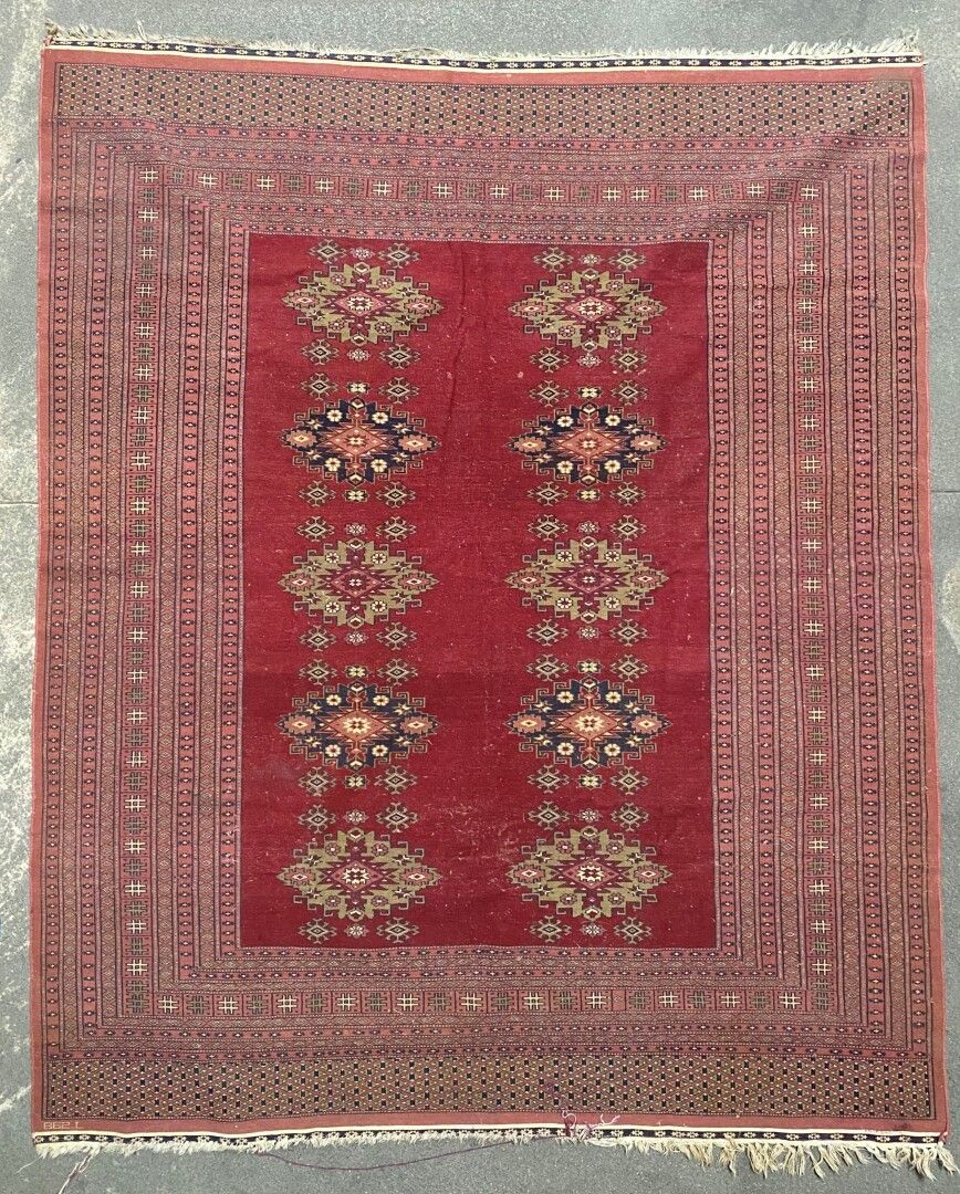 Null 巴基斯坦--地毯。

羊毛经线和纬线，羊毛起绒。

饰以红底宽边和几何图案。

现代。

225 x 180厘米。

磨损和小型修复。