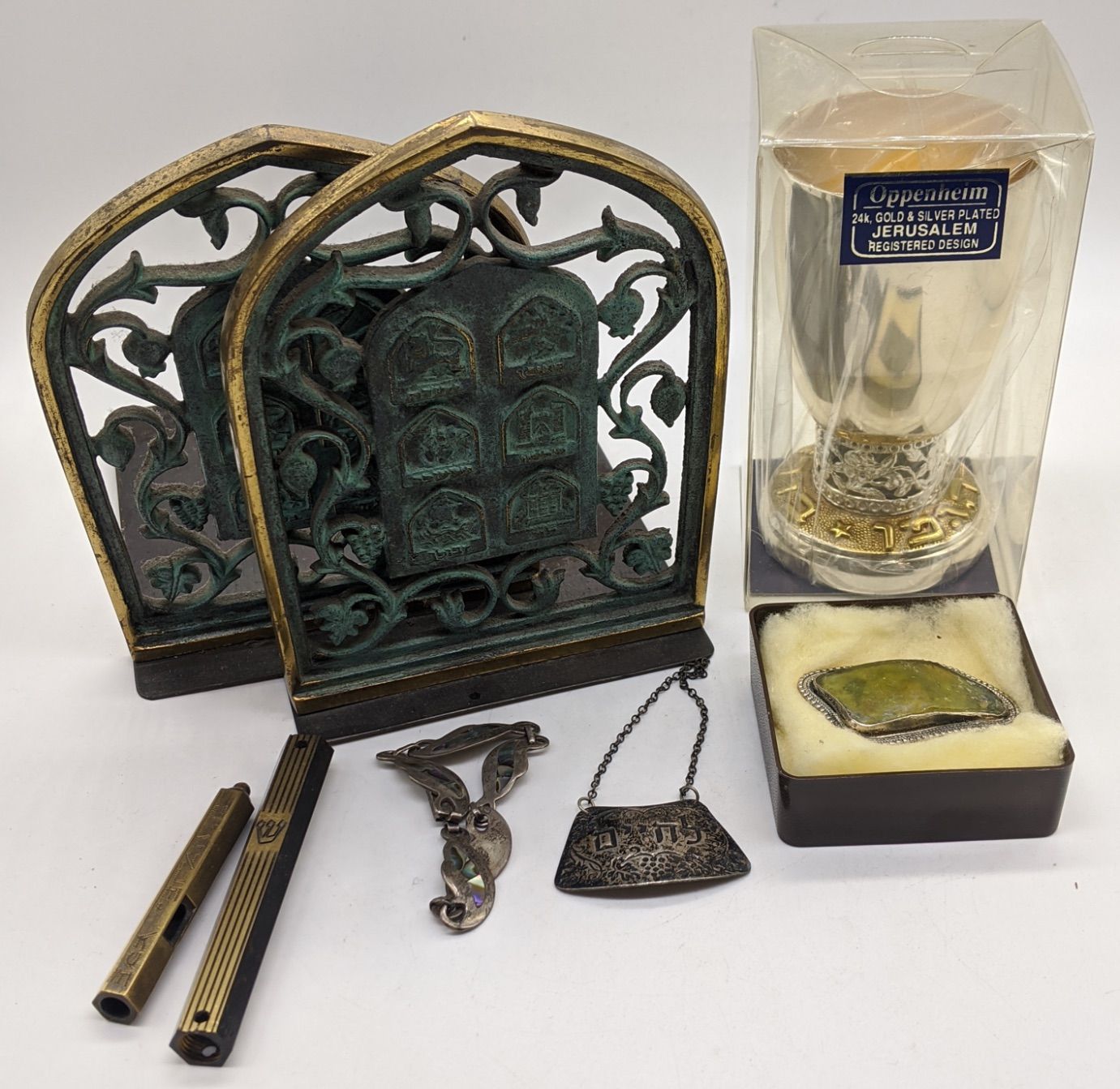 Null 一批犹太物品，包括一个银酒壶标签、一个银手镯、米苏扎、书架、白金属高脚杯和银胸针。