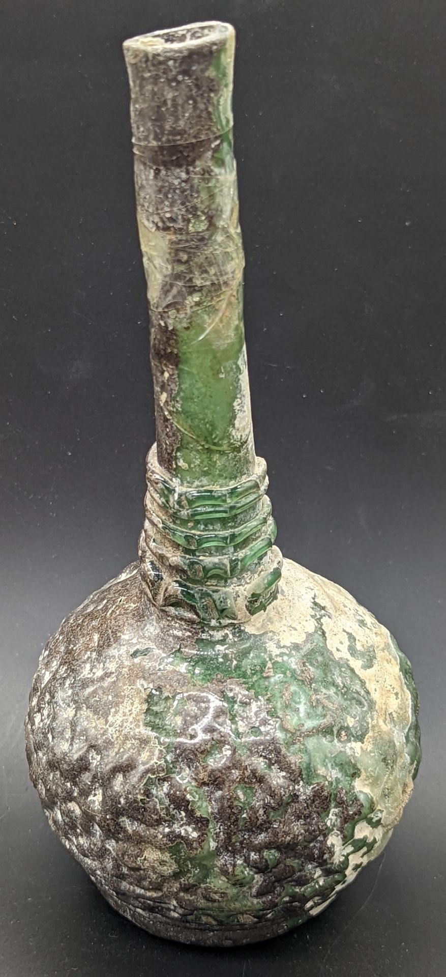Null A 10th century Islamic green glass baluster vase, H.20cm