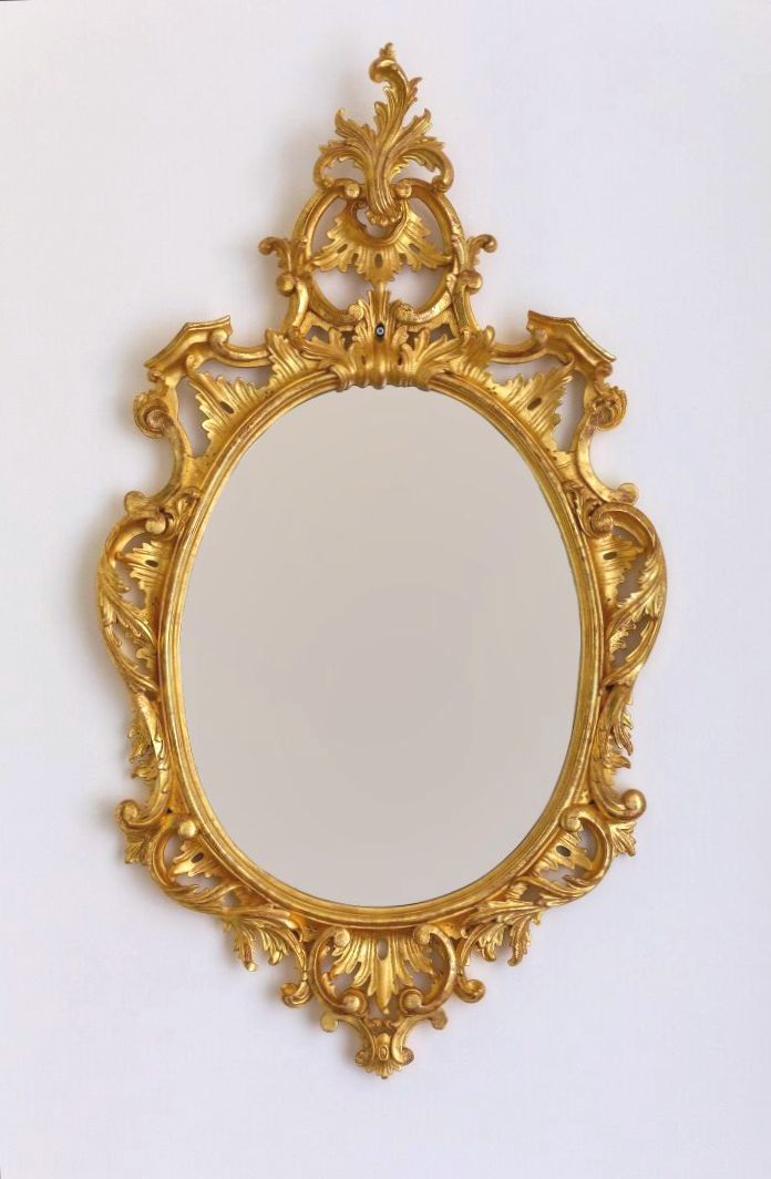 Null Miroir ovale en bois doré à décor ajouré de feuilles d'acanthes. 

Dans le &hellip;
