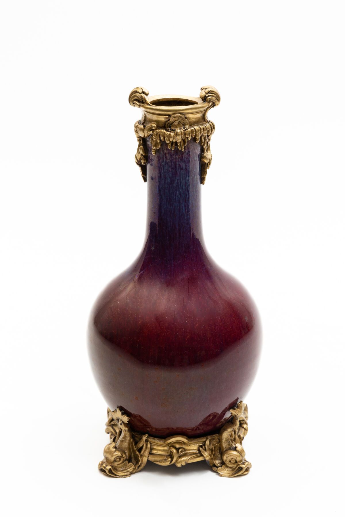 Null 一个红茄子色的火焰纹瓷器柱形花瓶，装在一个带有文艺复兴时期风格的玫瑰花和鱼的欧洲錾刻和鎏金铜框中。

中国，19世纪的瓷器，（可能没有穿孔）。

19&hellip;