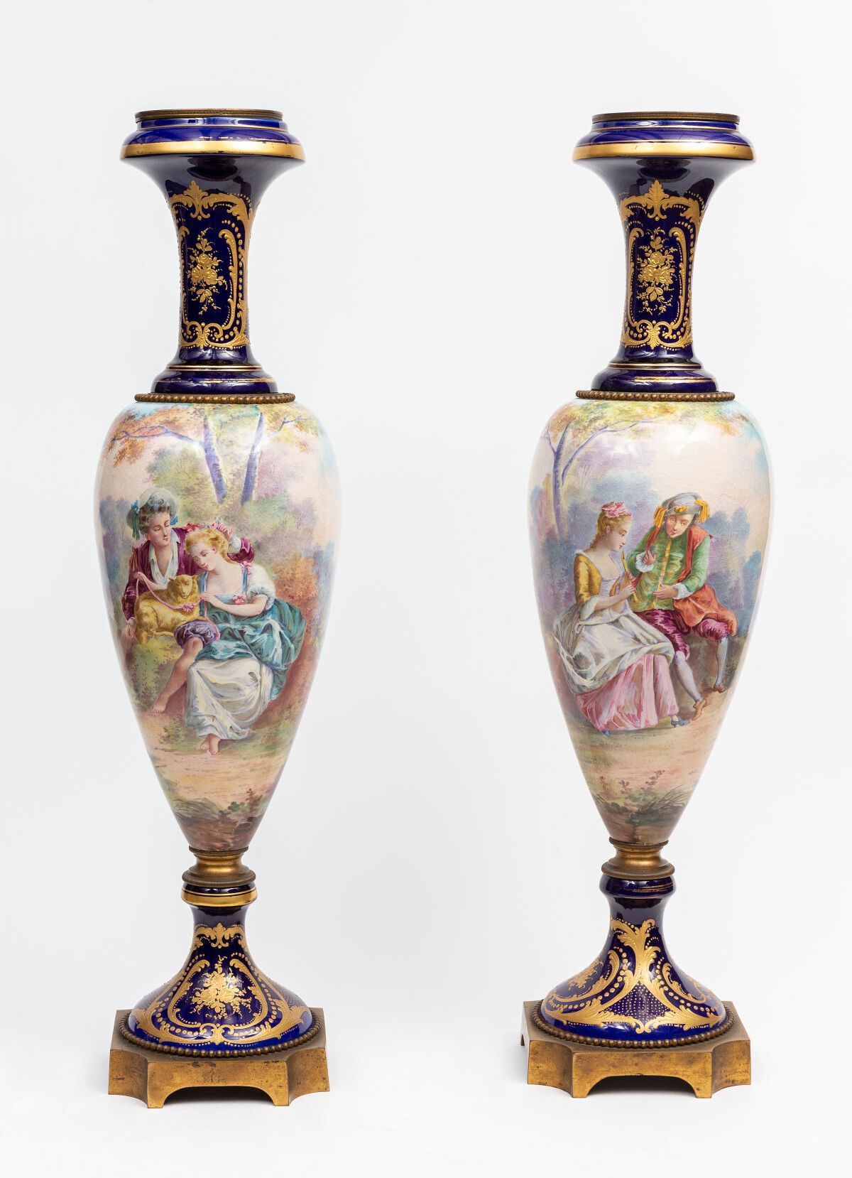 Null SÈVRES, in the taste of.

一对上等陶器的大柱形花瓶，带有珐琅彩。

绘有英勇场景的珐琅。

底部和颈部在美丽的蓝色背景上装饰&hellip;