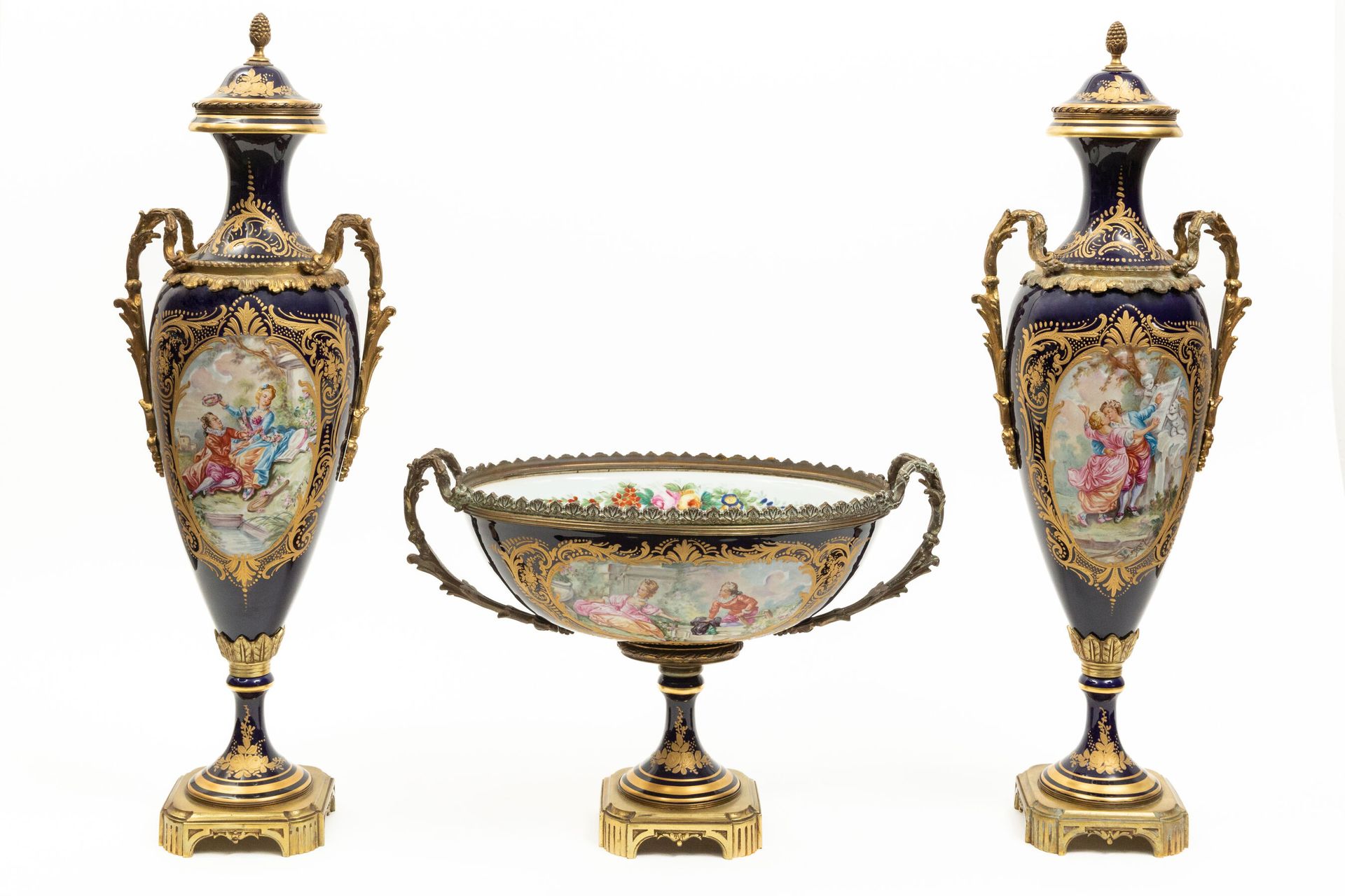 Null SÈVRES, in the taste of.

一套包括一对花瓶和一个椭圆碗的底座，瓷器上有多色和黄金装饰的英勇的夫妇和风景与溪流。

框架是由美&hellip;