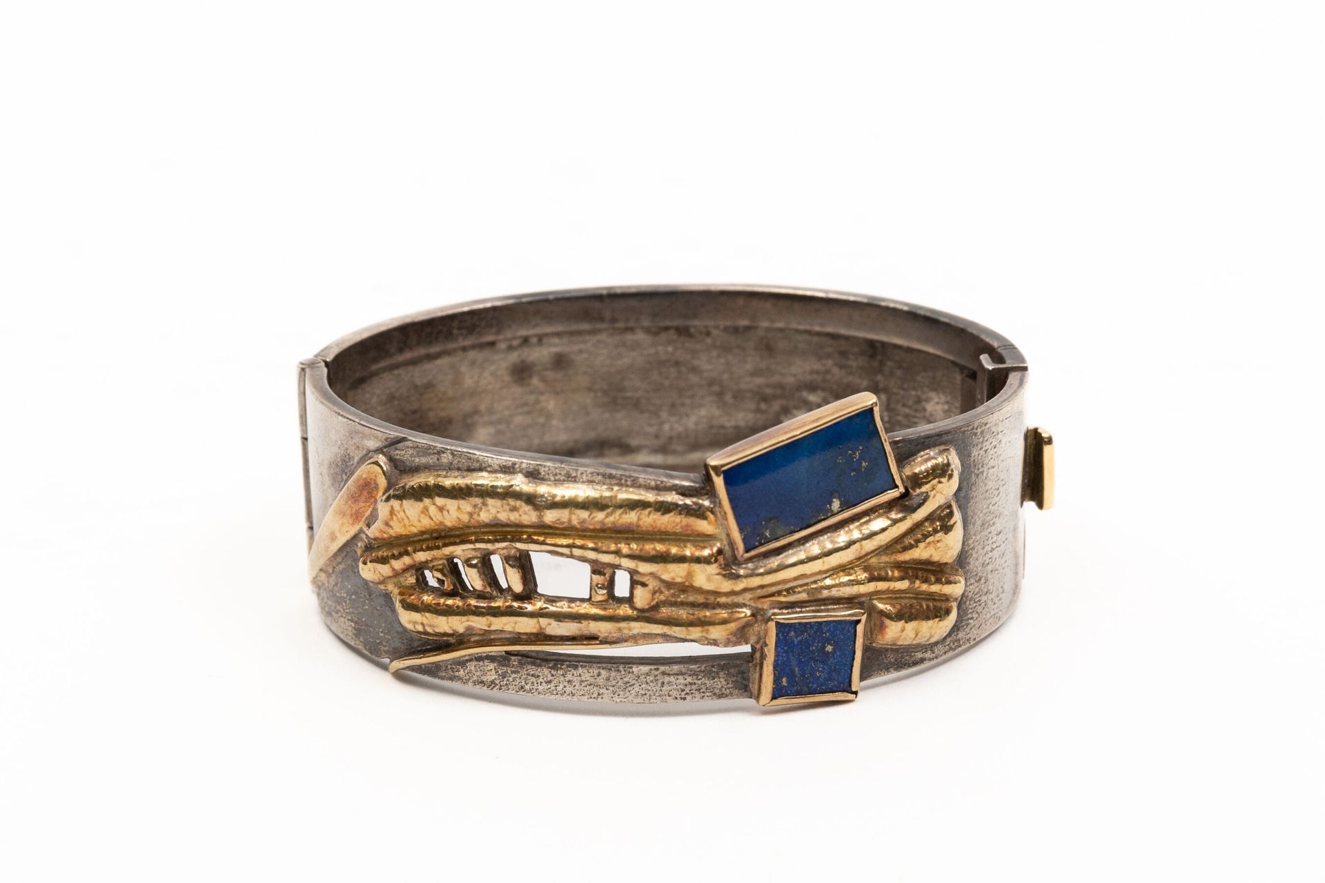Null 弗朗哥-卡迪纳利（1926-1985）。

手镯开口，银色和银色鎏金。

它有两个青金石元素的装饰。

签名。

毛重：63.92克，925°/00。&hellip;